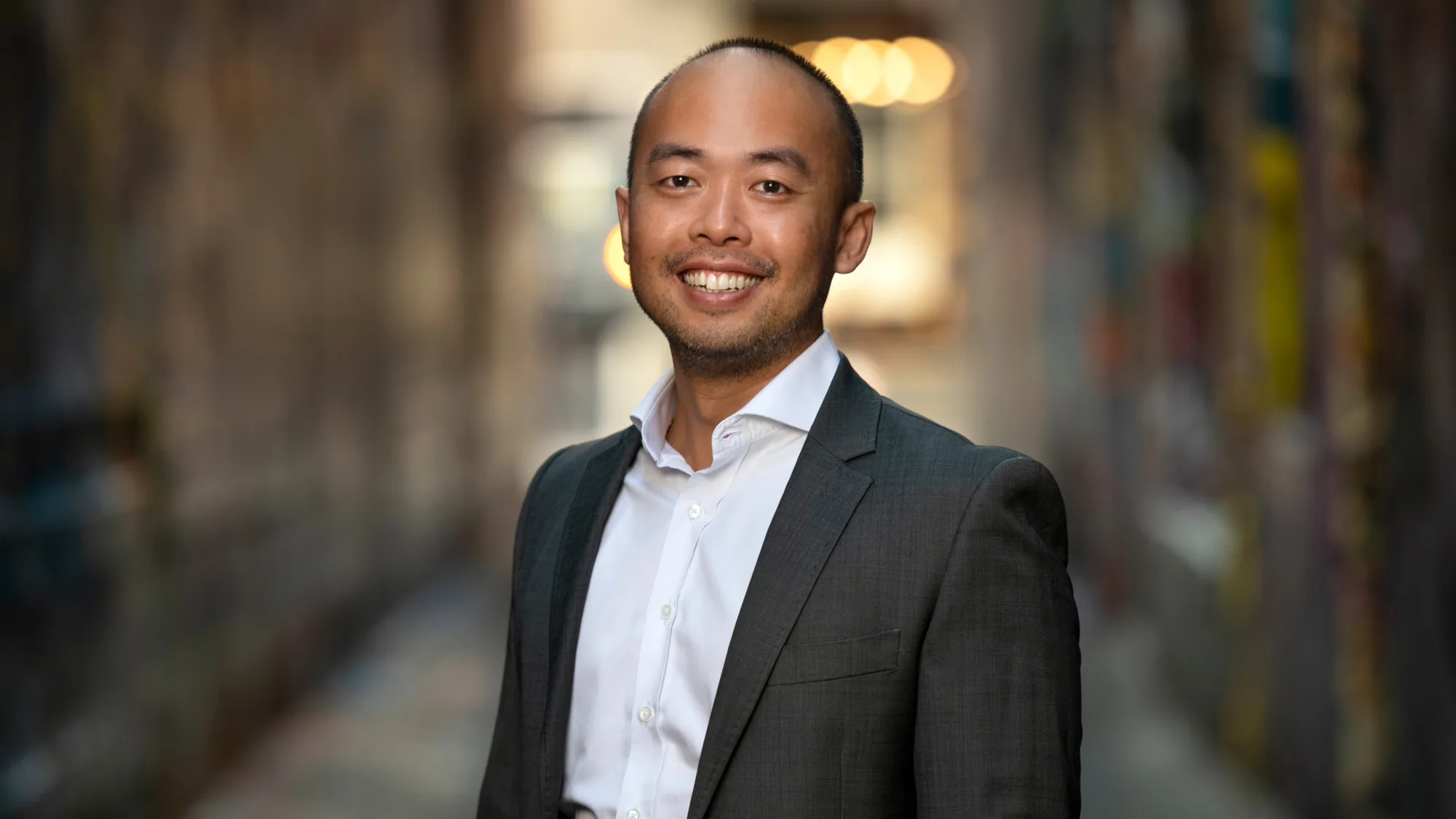Benny Cheah in a suit and white shirt with a street background blurred
