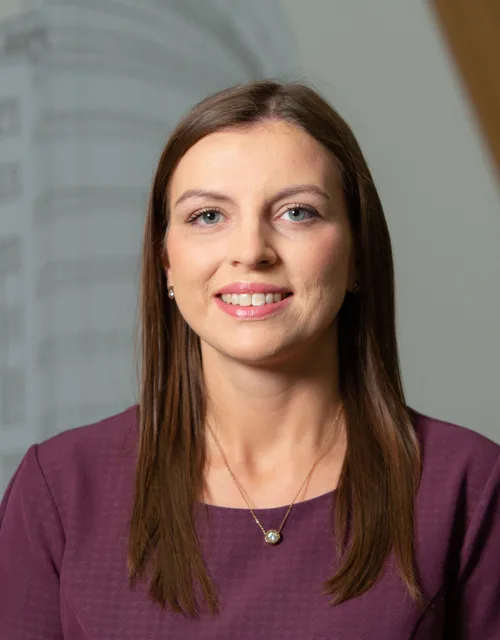 Head and shoulders shot of Rachel wearing burgundy top