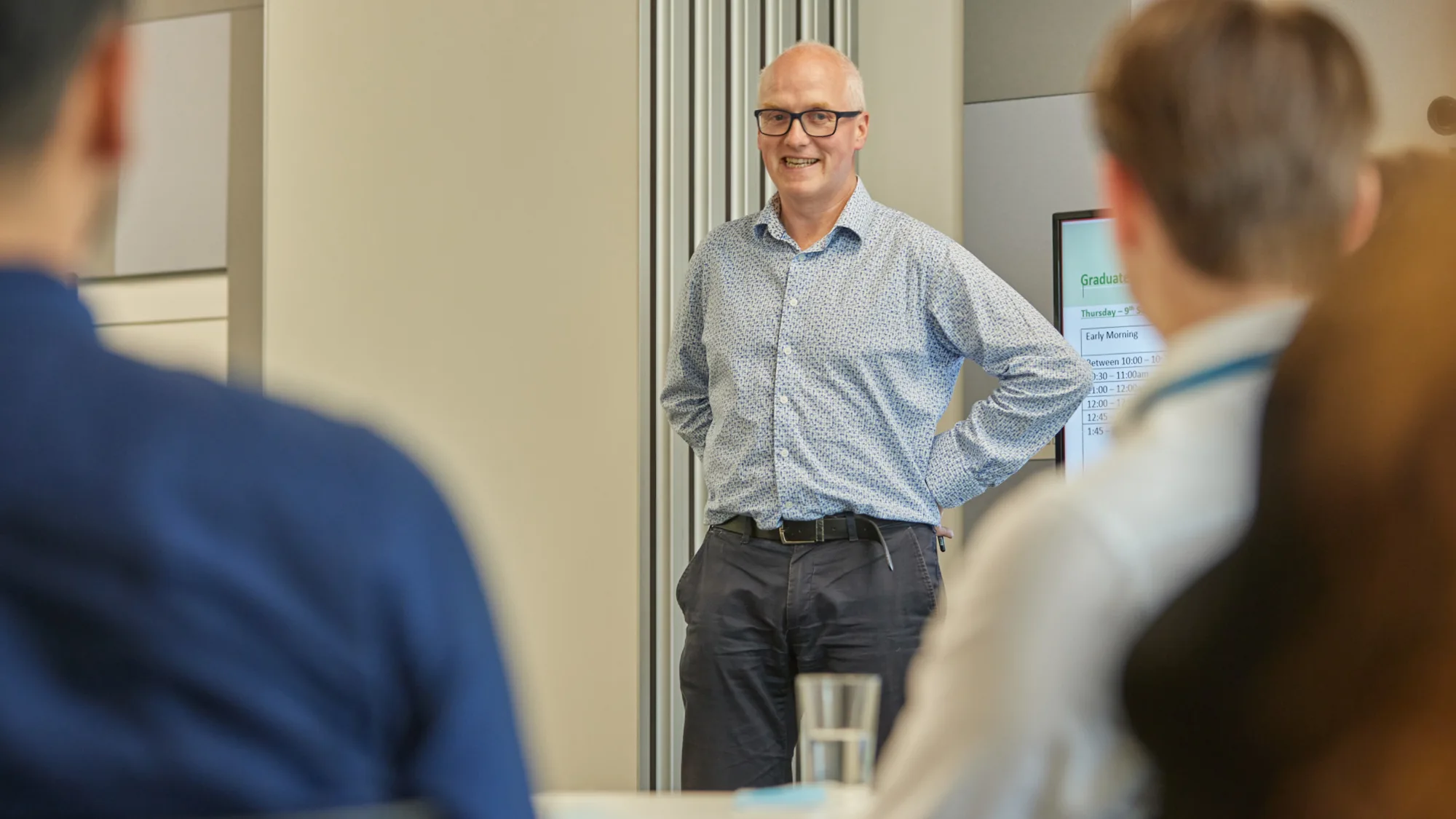 Tomas Neeson standing in a meeting looking at people