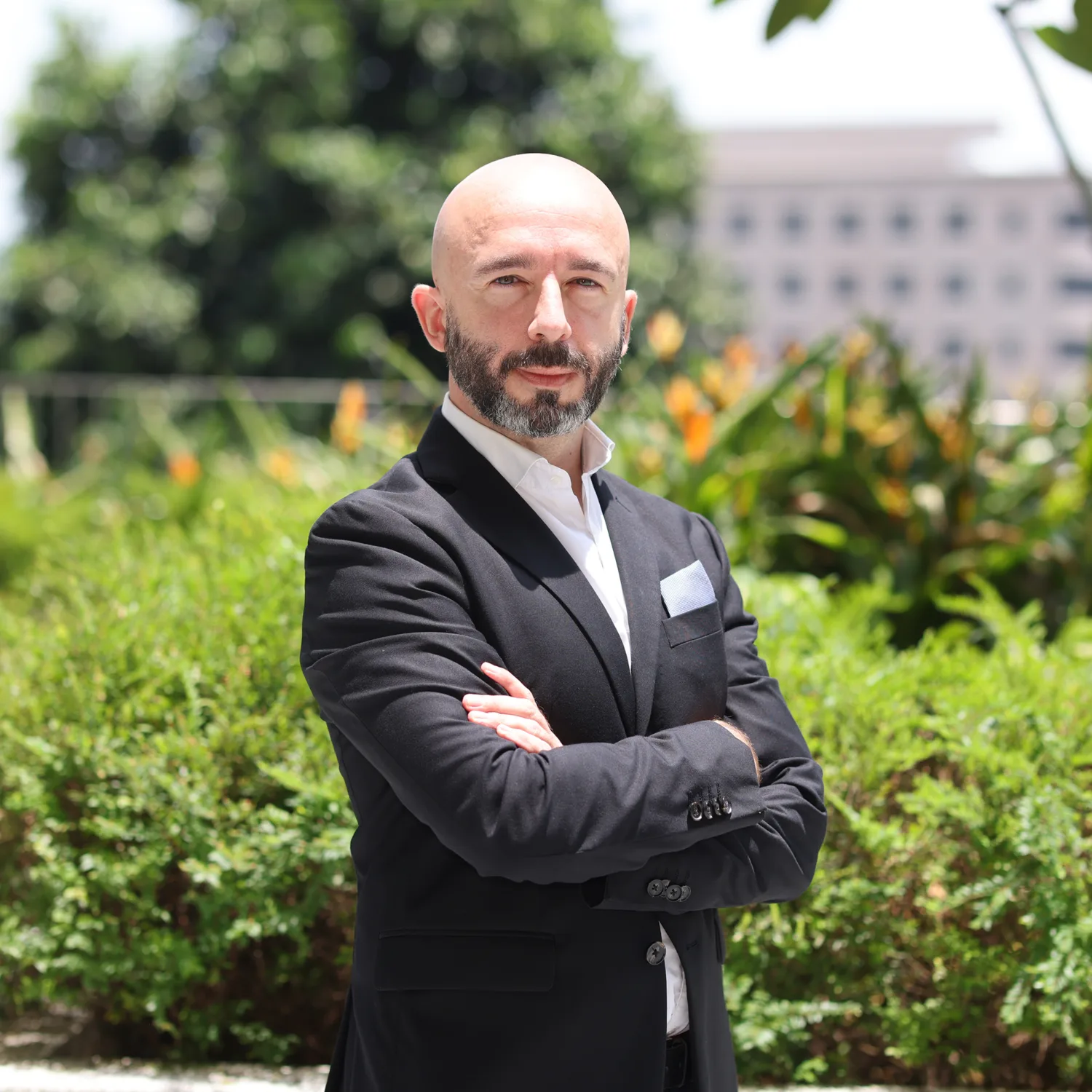 Alex Saez in park with trees and grass background