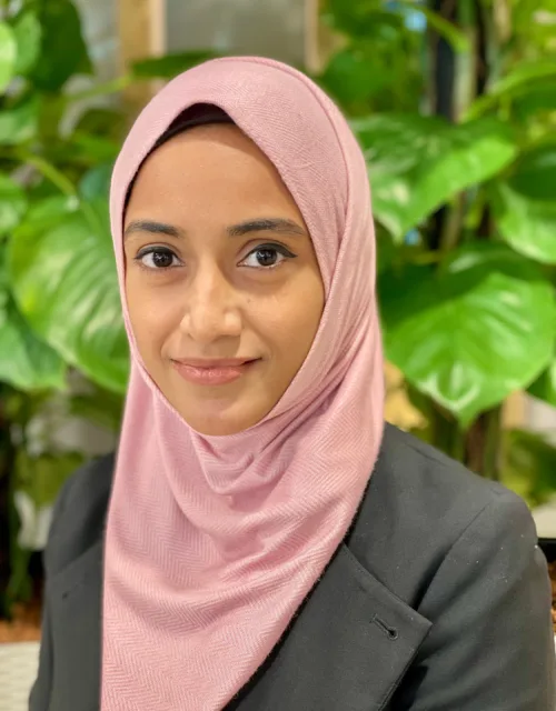 Anesah Begam posting for a photo while wearing her silky pink Hijab in our Singapore office