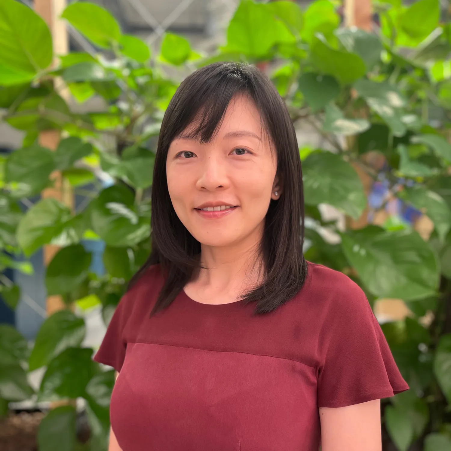Chaoming Yu in red top with plants in background