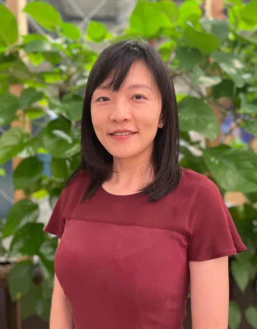 Chaoming Yu in red top with plants in background