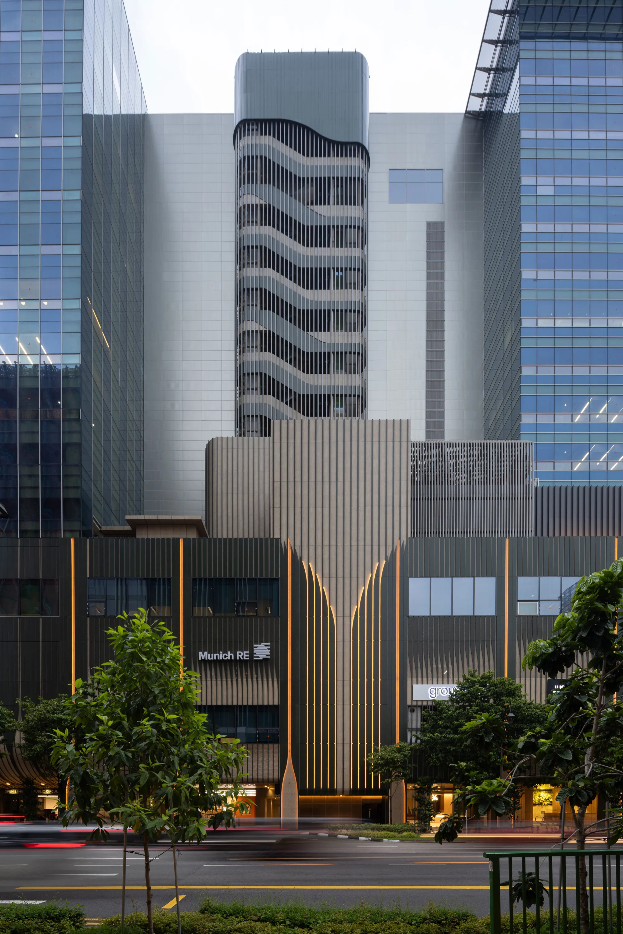 18 Cross building with its staircase facade, with trees and a street in front.