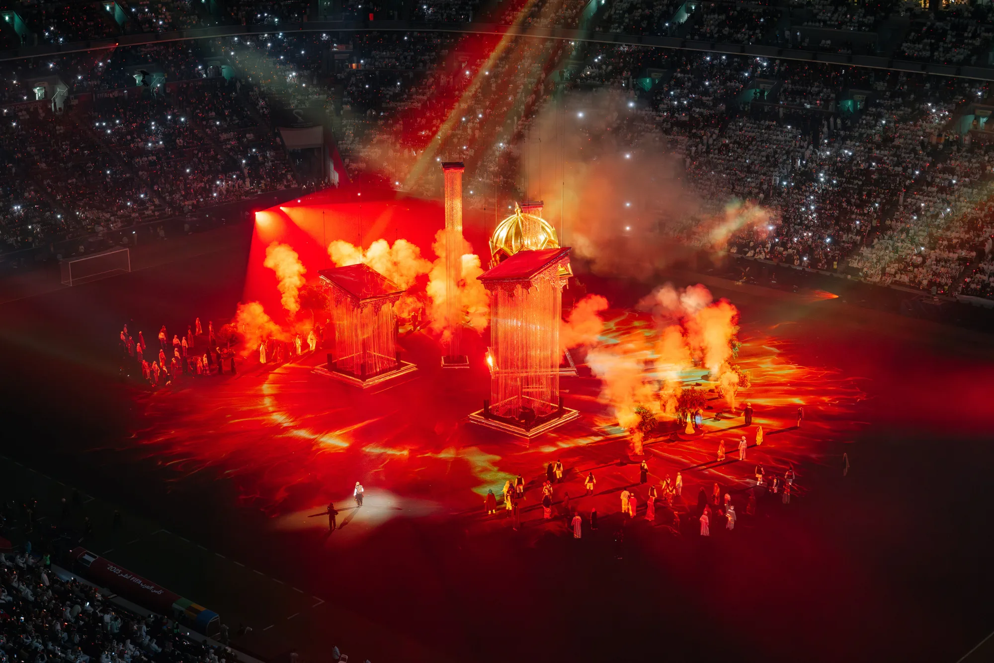 Shot of the arena plumes of orange smoke rising and dancers.