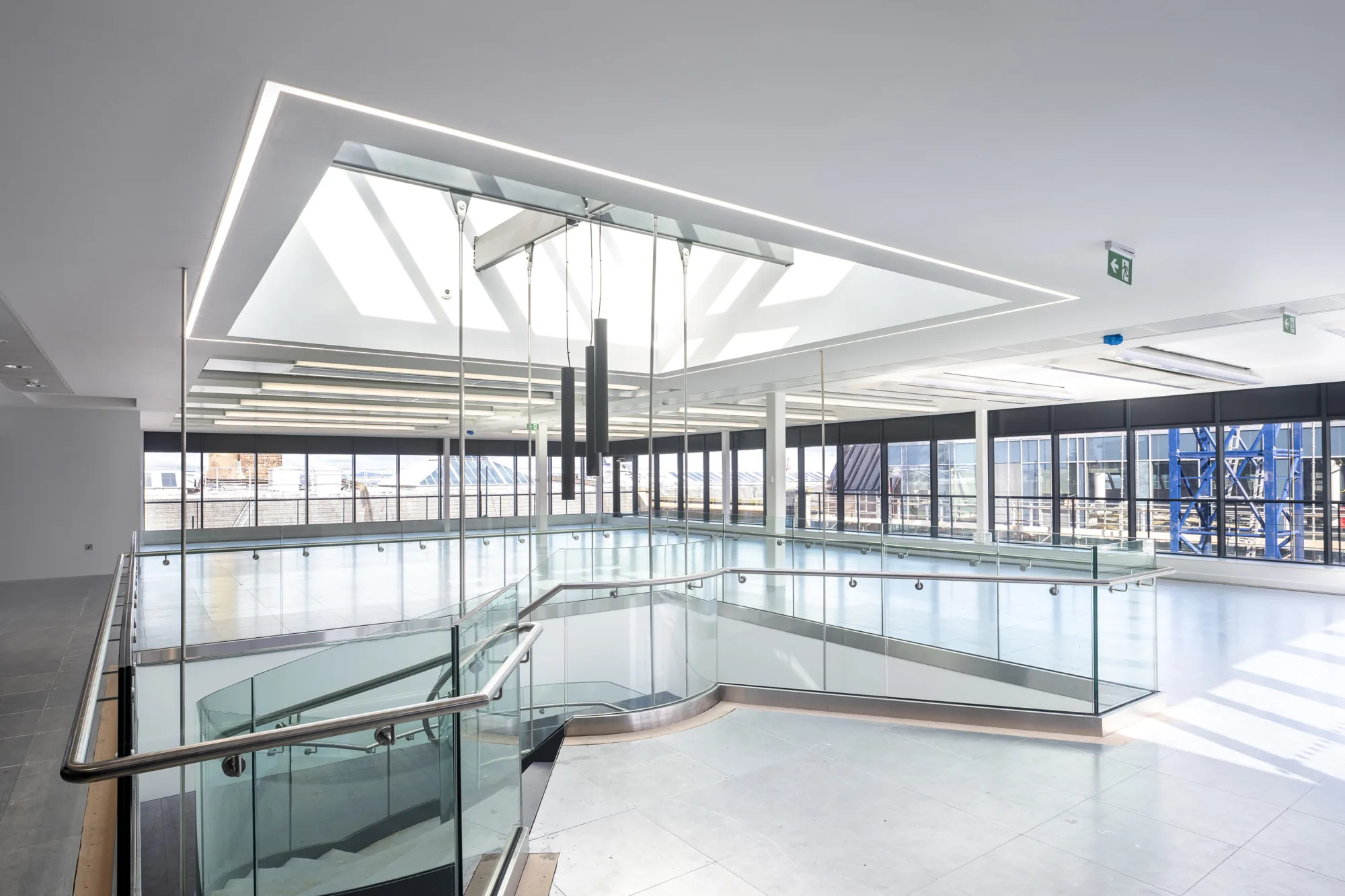 Modern interior of Andrews Square featuring a spacious veranda bordered by contemporary steel and glass railings.