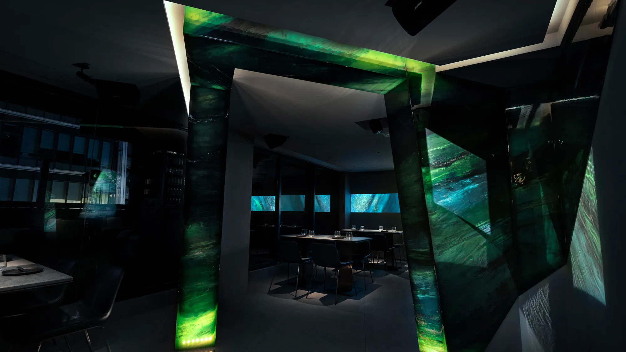 AOAO bar counter with spotlighting and wall is decorated with green gemstones.