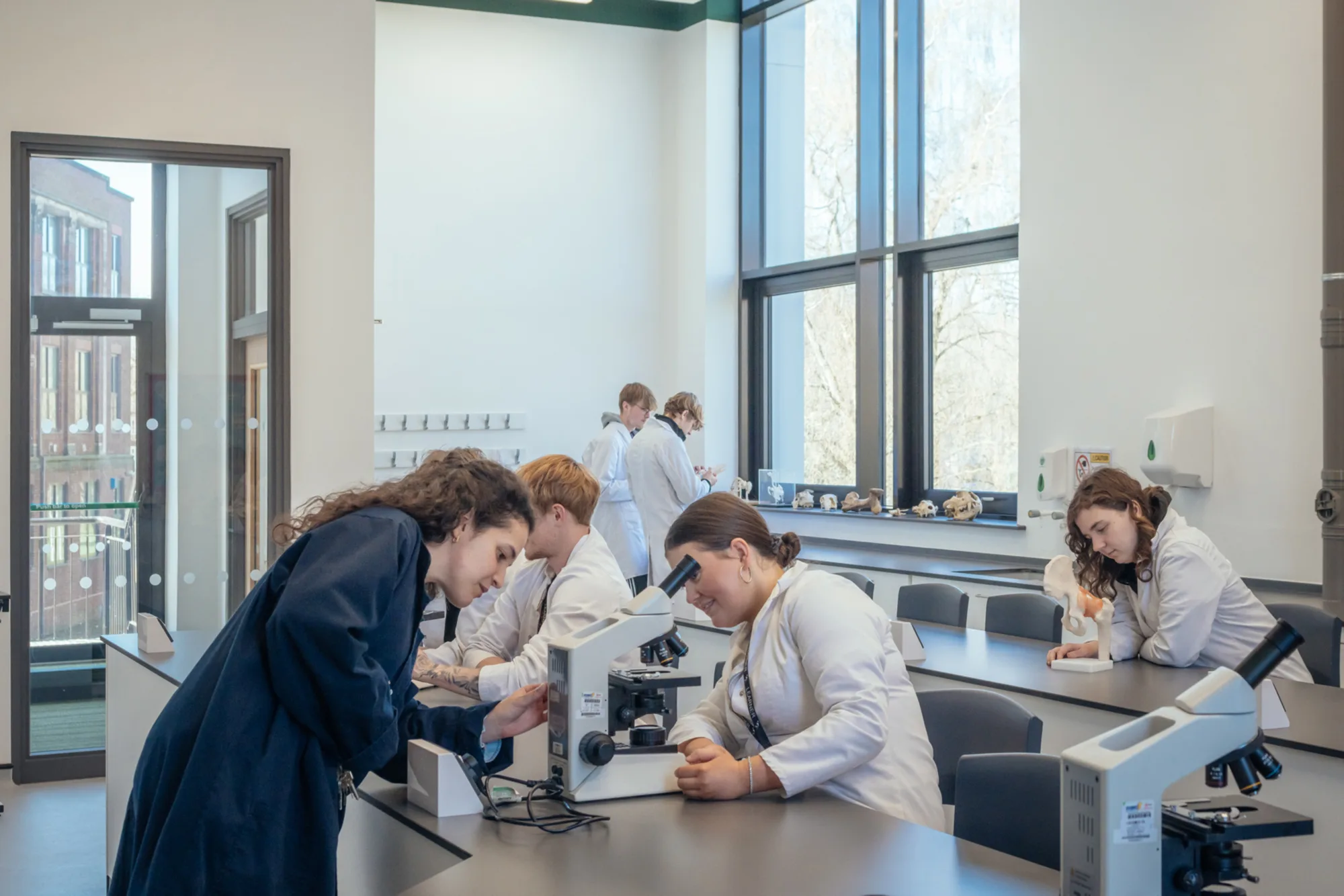 lab within the Animal Studies Centre with students and a teacher using microscopes.