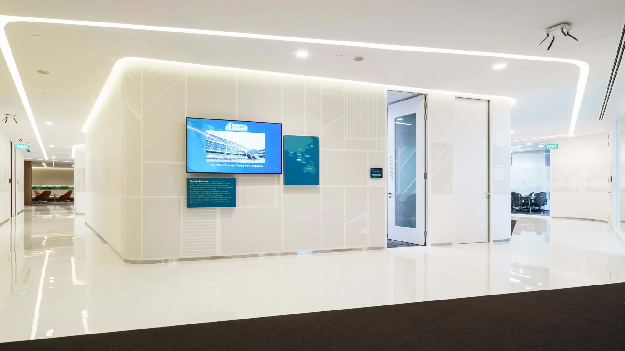 External view of meeting room with large-screen TV on the wall and flanked by spacious marble-tiled hallways on either side with overhead LED strip lights