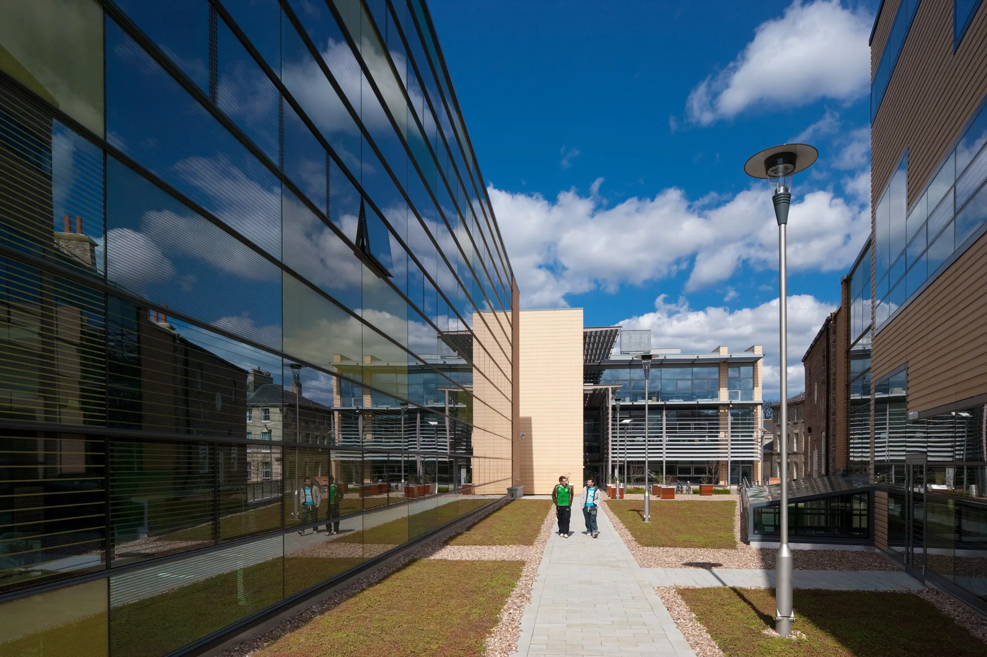 People walking on a path adjacent to the glazed building