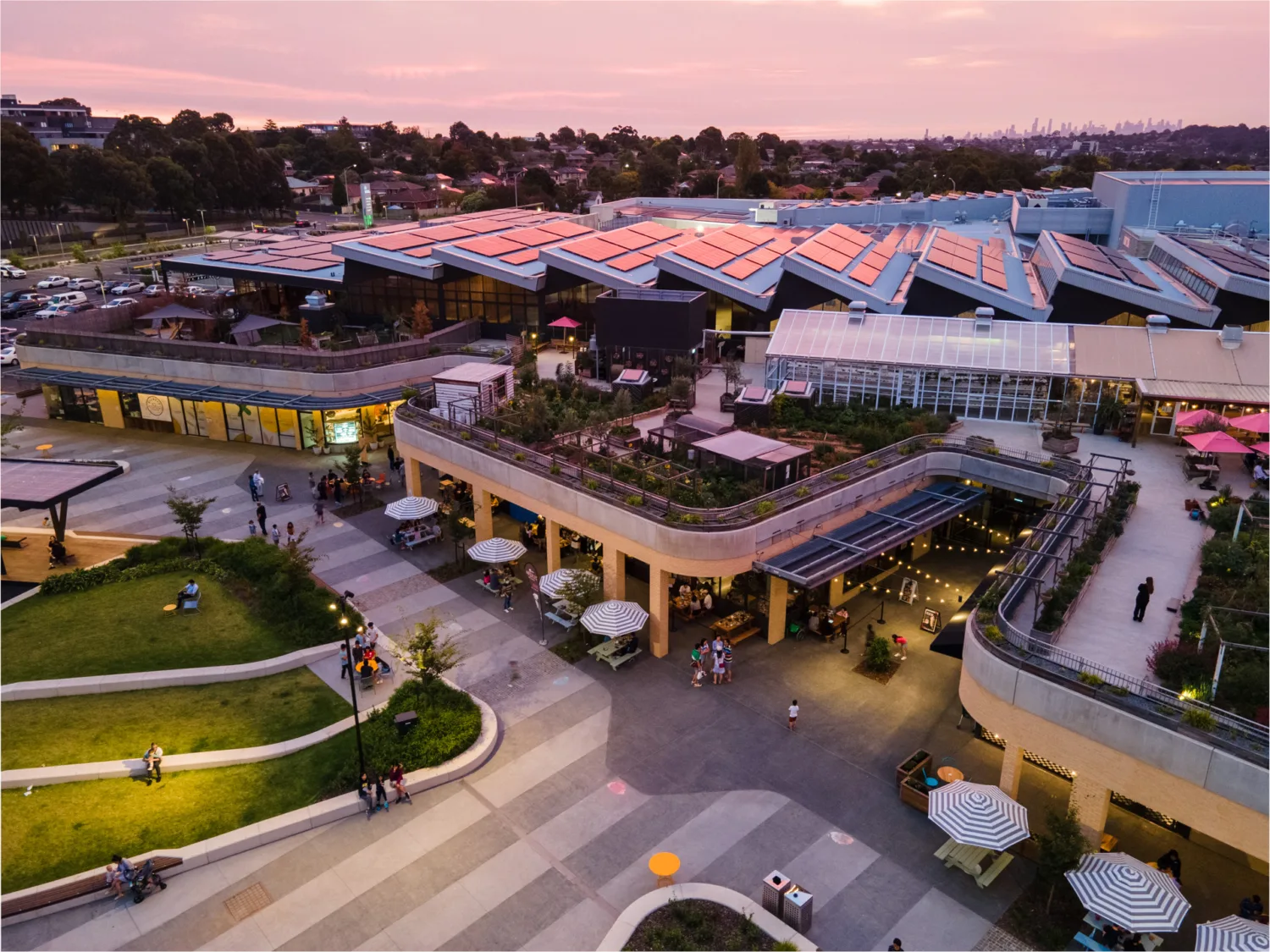 Aerial view of complex at dusk including solar panels and surrounds.