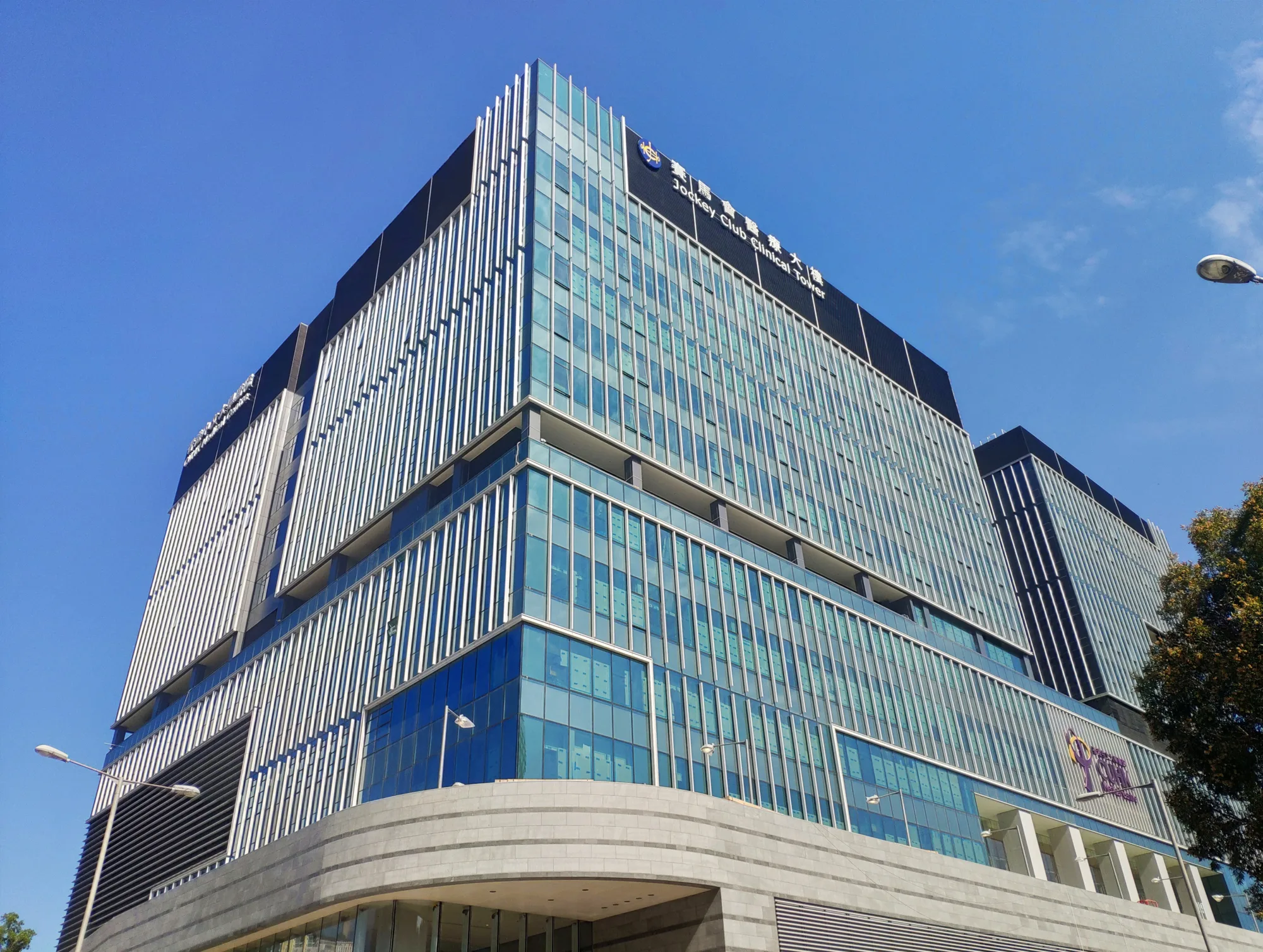 Upwards view of the building exterior with a just visible black sign an white writing