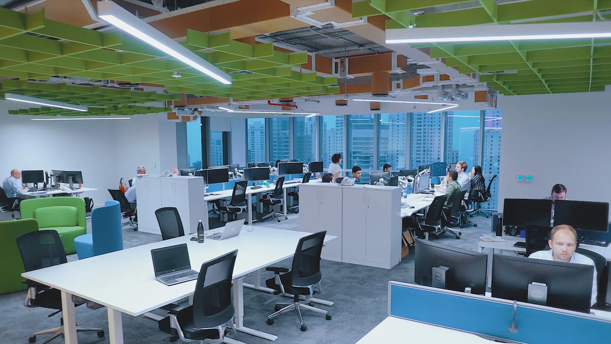 Cundall Dubai WELL office with employees working on their workstations having a beautiful view of Dubai Marina