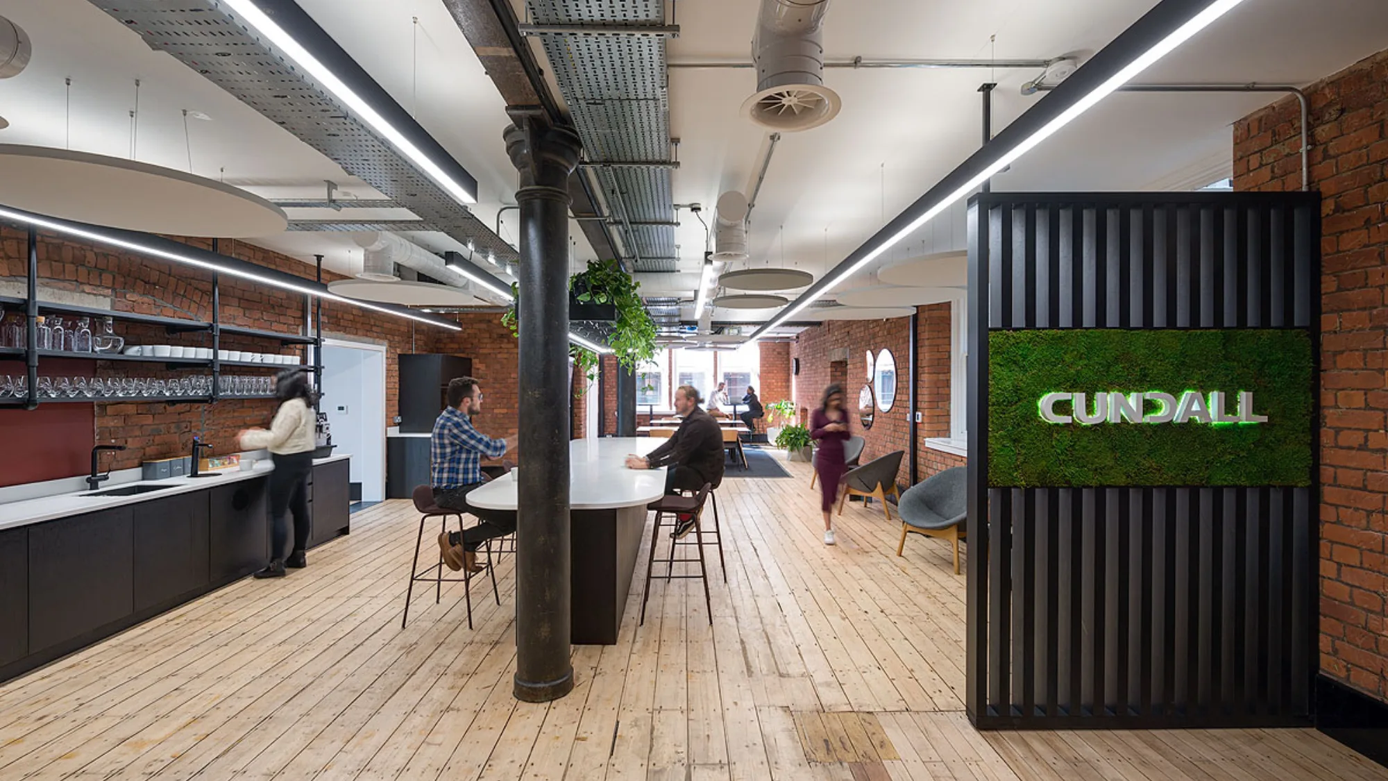 Wooden floor and brick walls in an open plan workspace in Cundall Manchester office