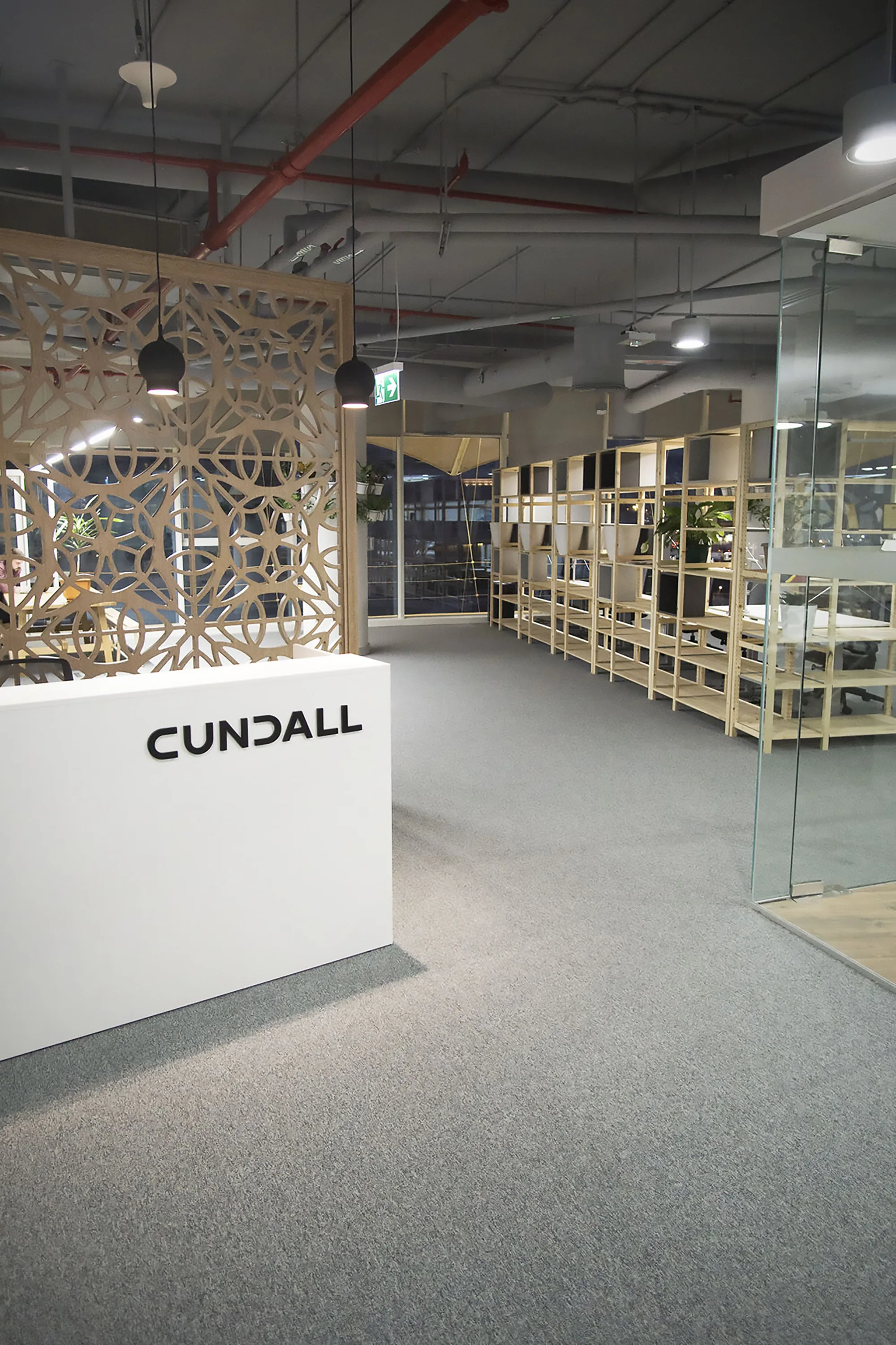 Cundall Qatar Well office reception area with white receiving desk and wooden divider with arabic ornament design