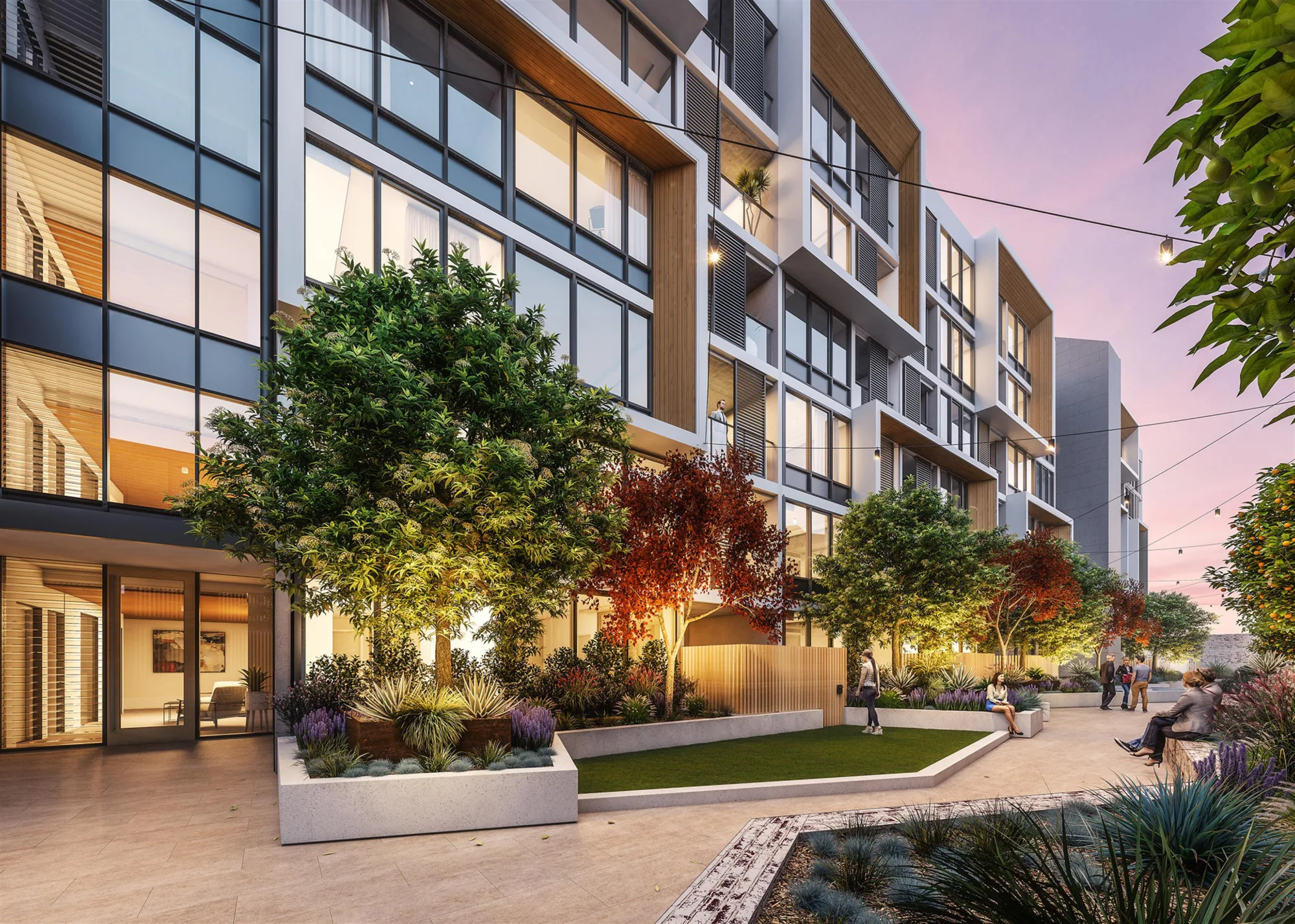 Exterior shot of apartment building at dusk with people sitting and socialising
