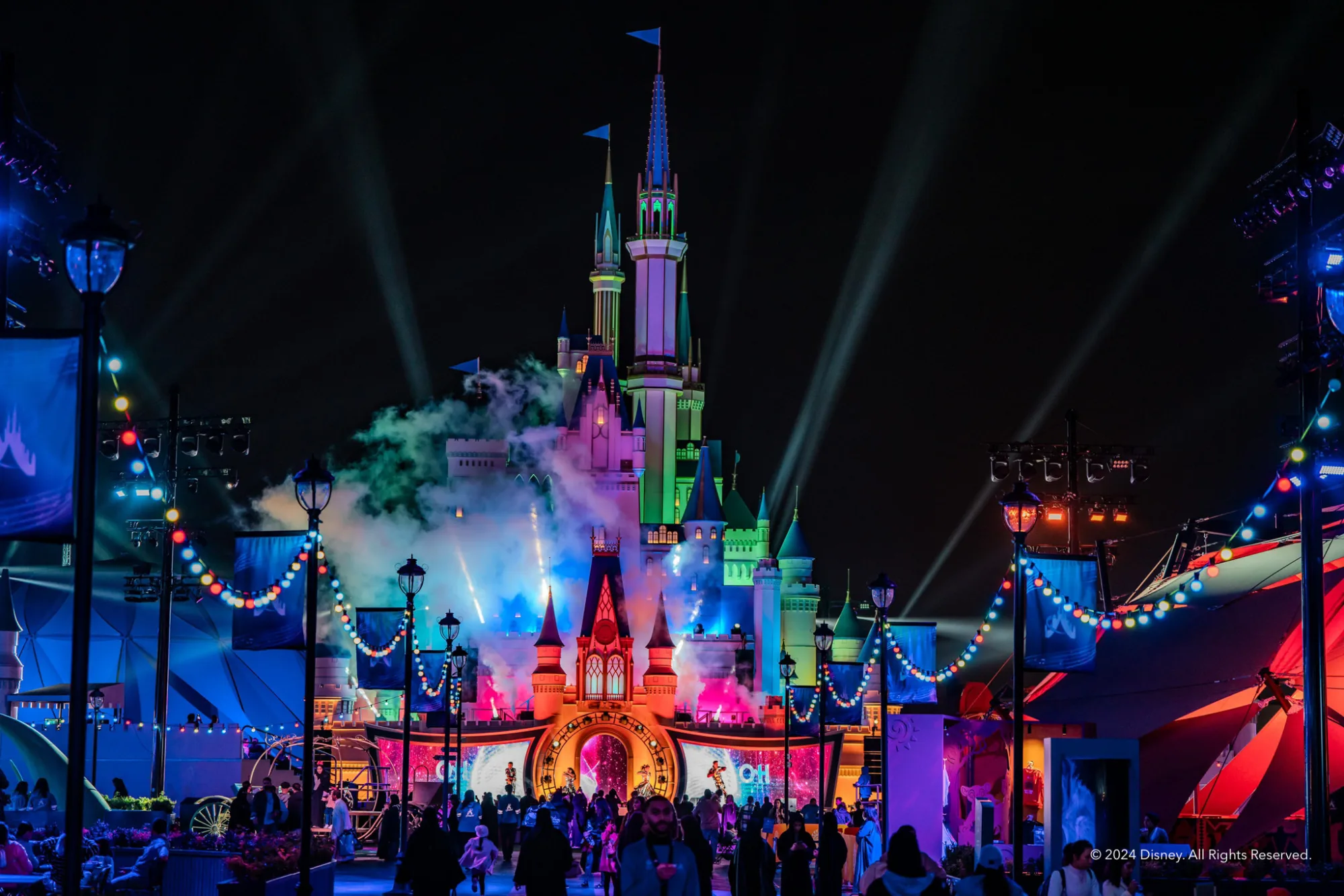 Disney Castle with rainbow lighting at night