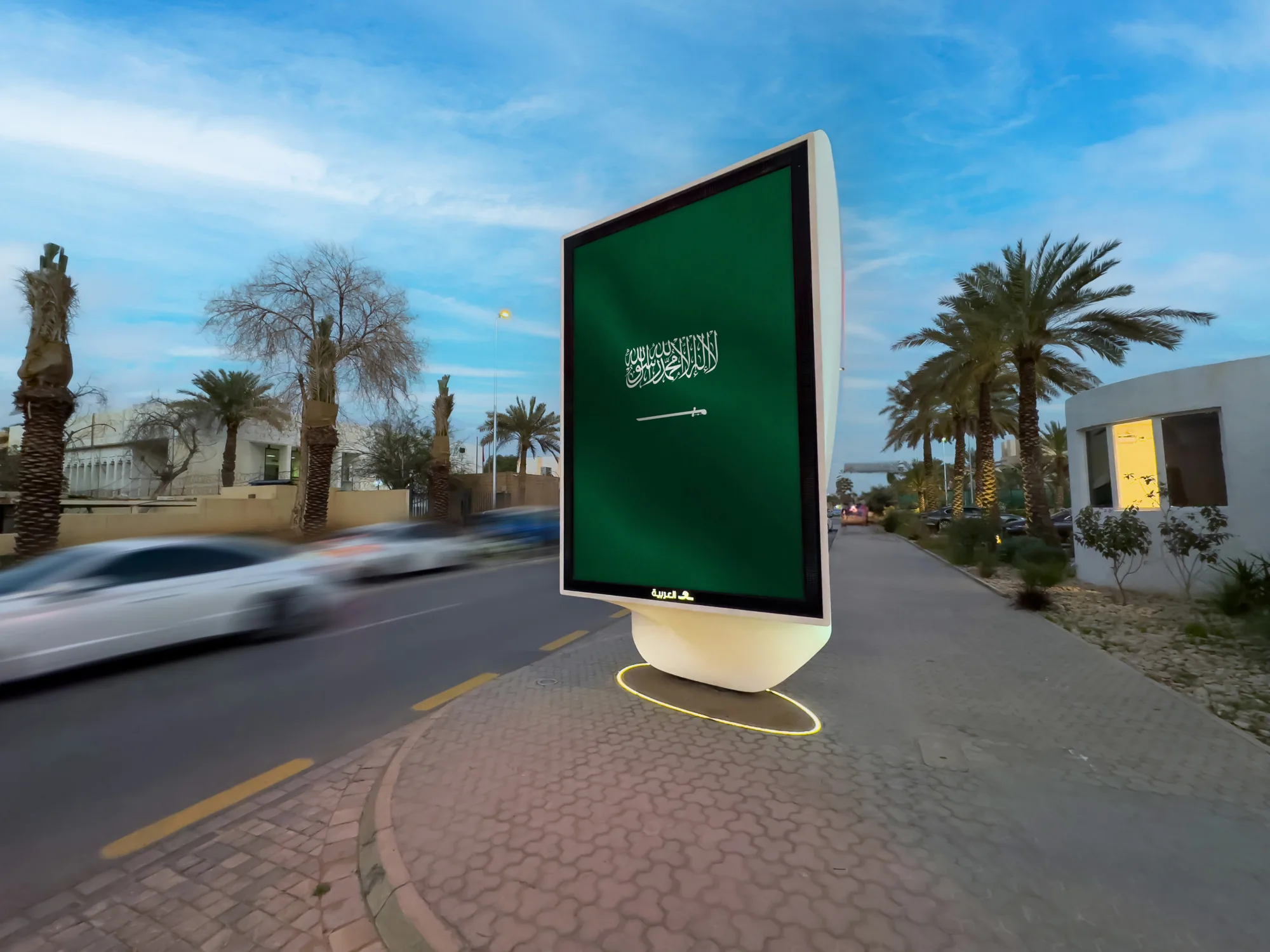 The digital advertising sculpture photographed from LED screen side during day with driving cars in the background
