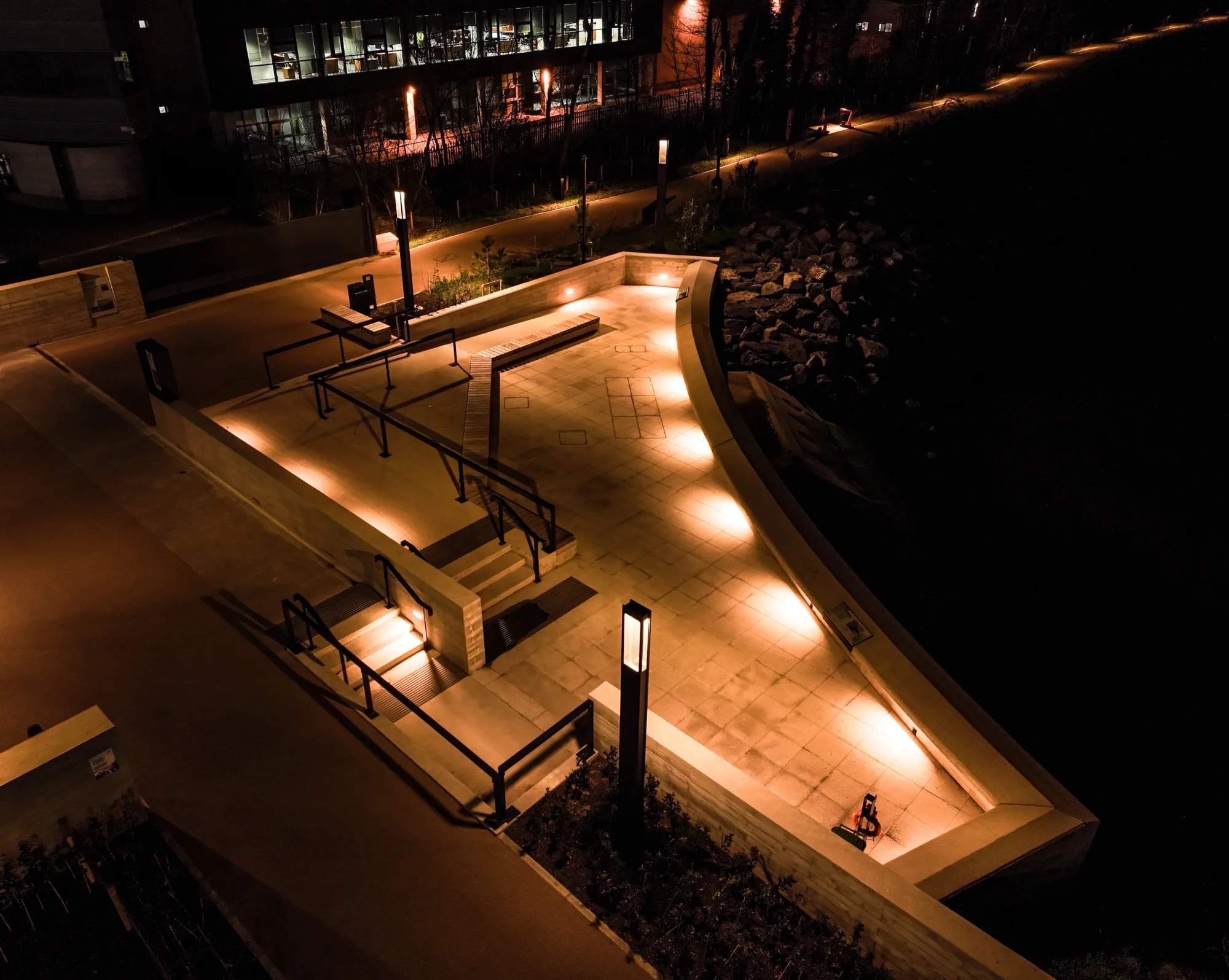 A curved paved viewing point at night with floor lighting