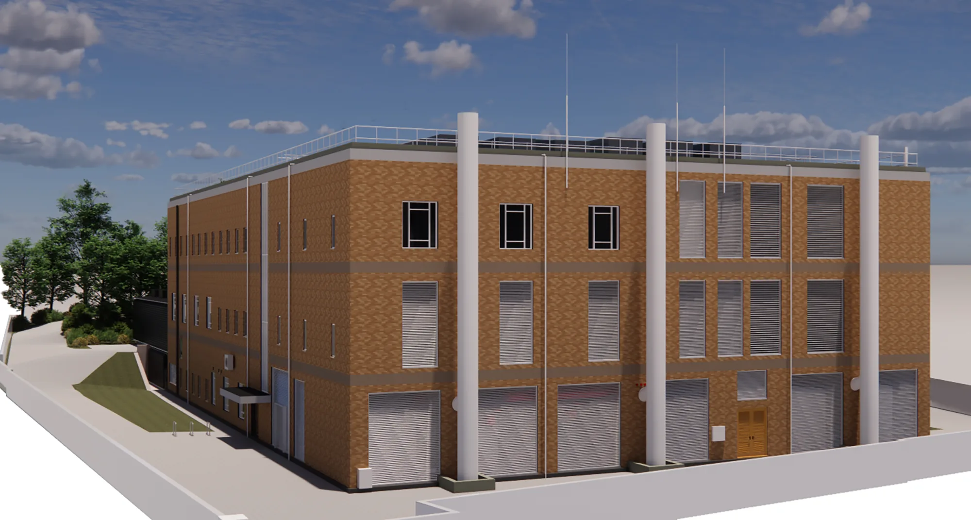 A three‑storey brick building with multiple rectangular windows, tall vertical pipes, metal roller shutters, and a small door. The structure sits beside a paved area with trees and a partly cloudy sky in the background.