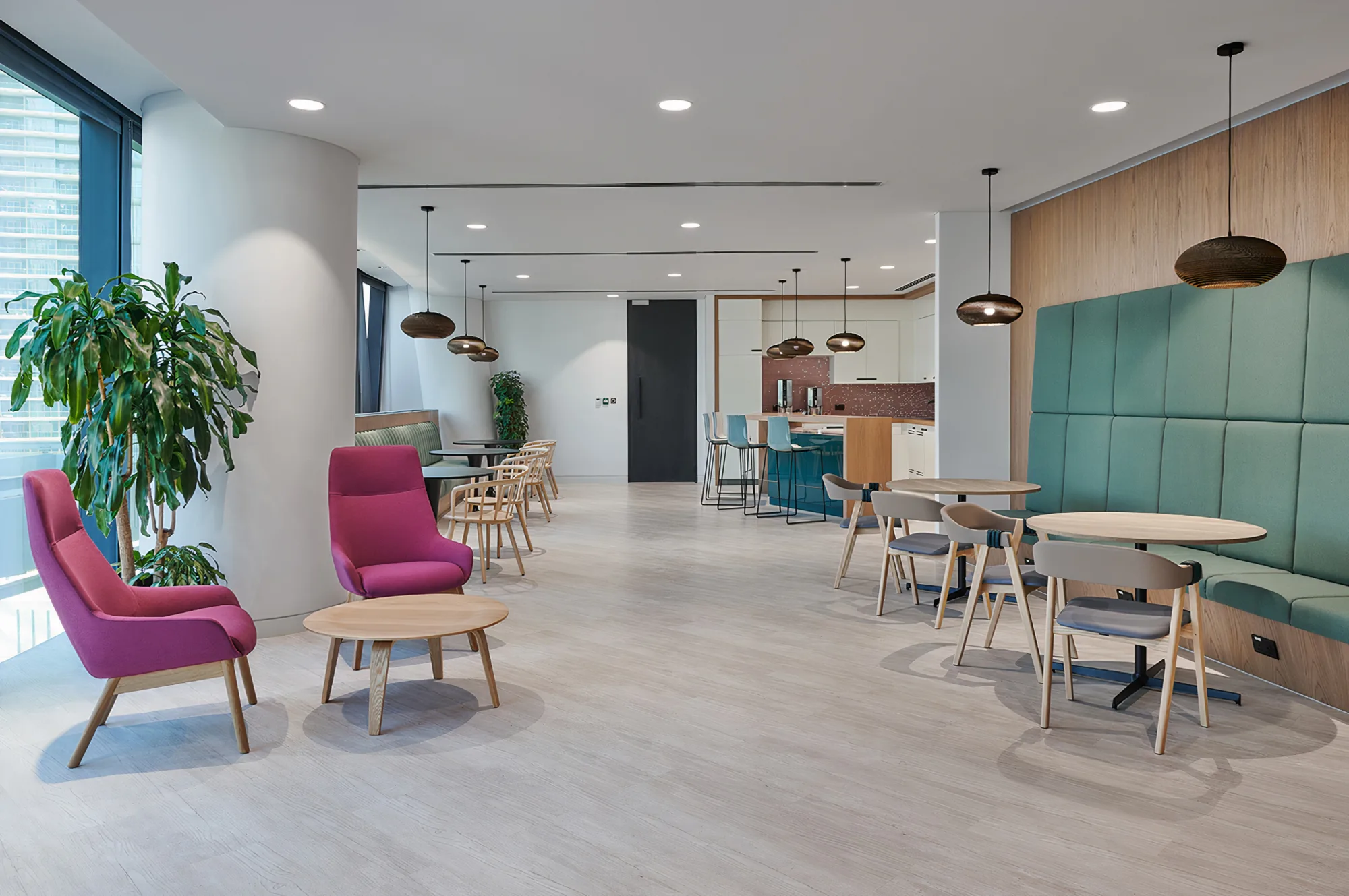 EY Dubai office pantry area with bar counter, coffee makers and tables.