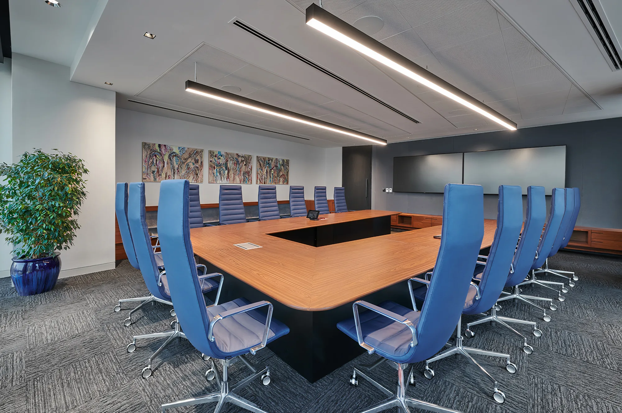 EY Dubai office meeting room with a large long table that can accommodate up-to 15 people. The room also has 2 large TV's for presentation and a carpet flooring