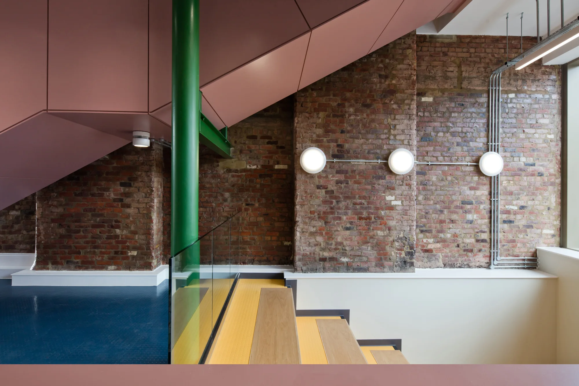 Colourful staircase in front of exposed brick wall
