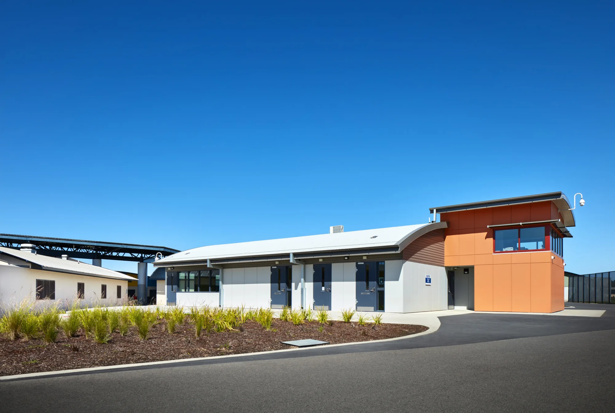 Exterior view of main entrance to Fulham Correction Facility with blue sky background.