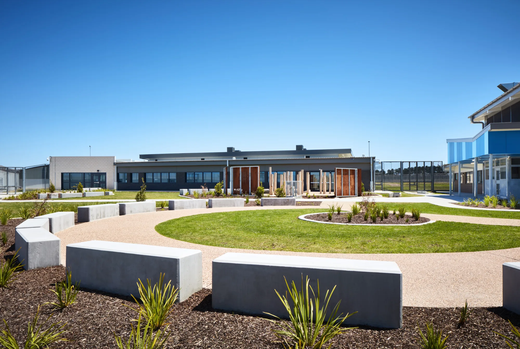 View of courtyard grassy area and concrete seating surrounds.