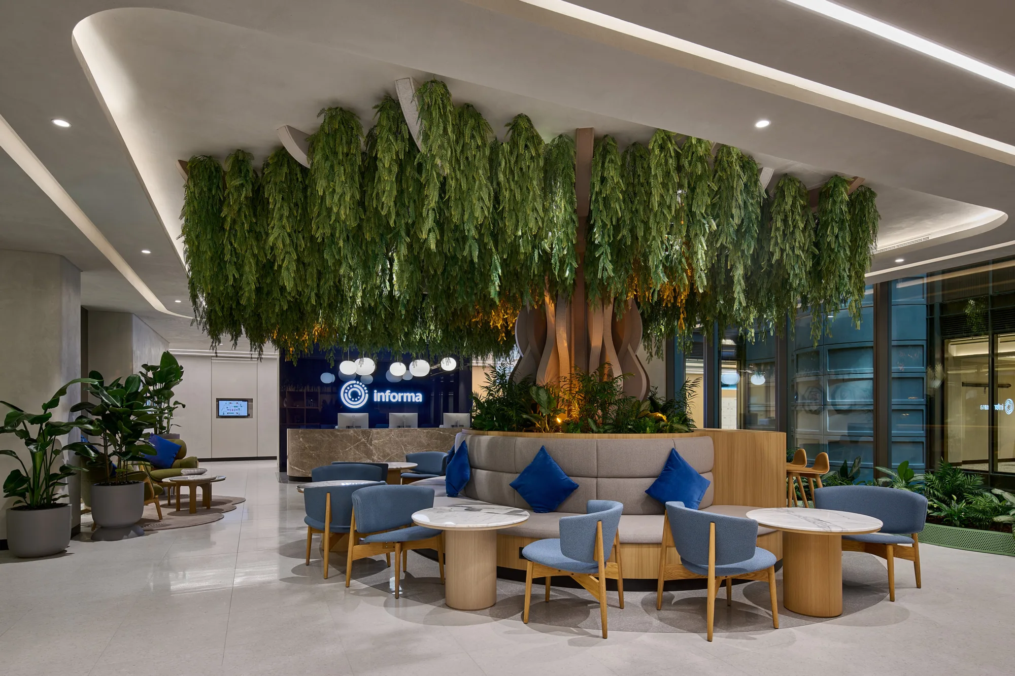 Informa reception area with seating and a large tree inspired art decoration in the centre of the room.