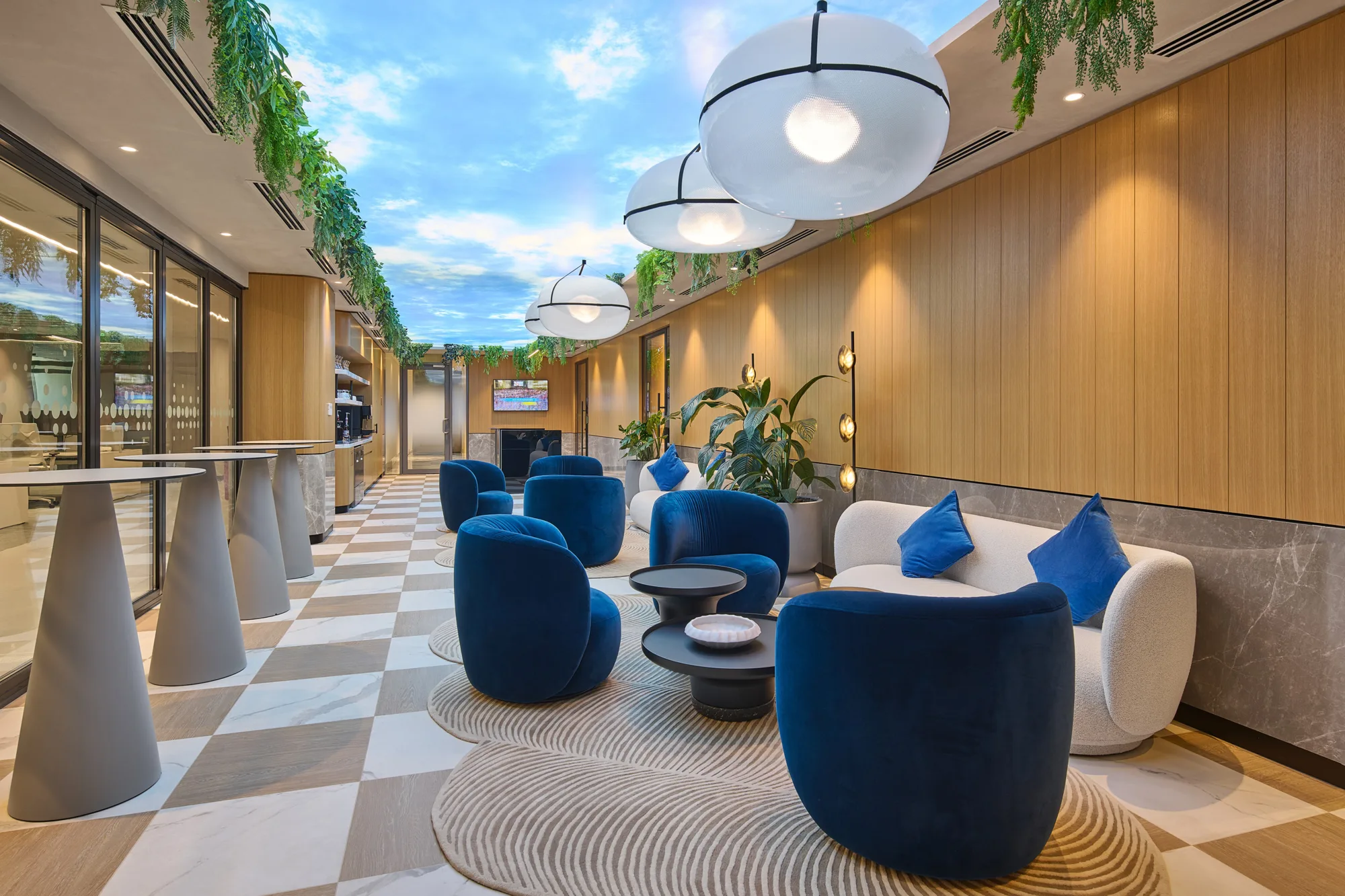 Informa office seating area with blue and cream sofa chairs and a Michelangelo inspired blue sky art on the ceiling.