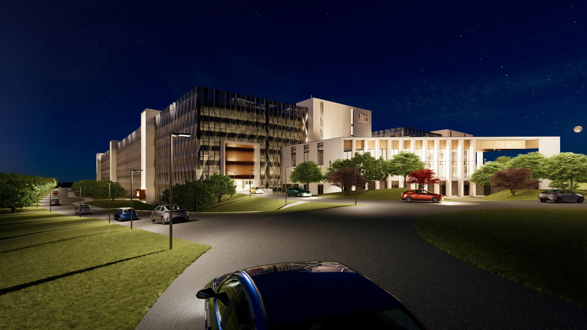 View of carpark at night with cars on the road