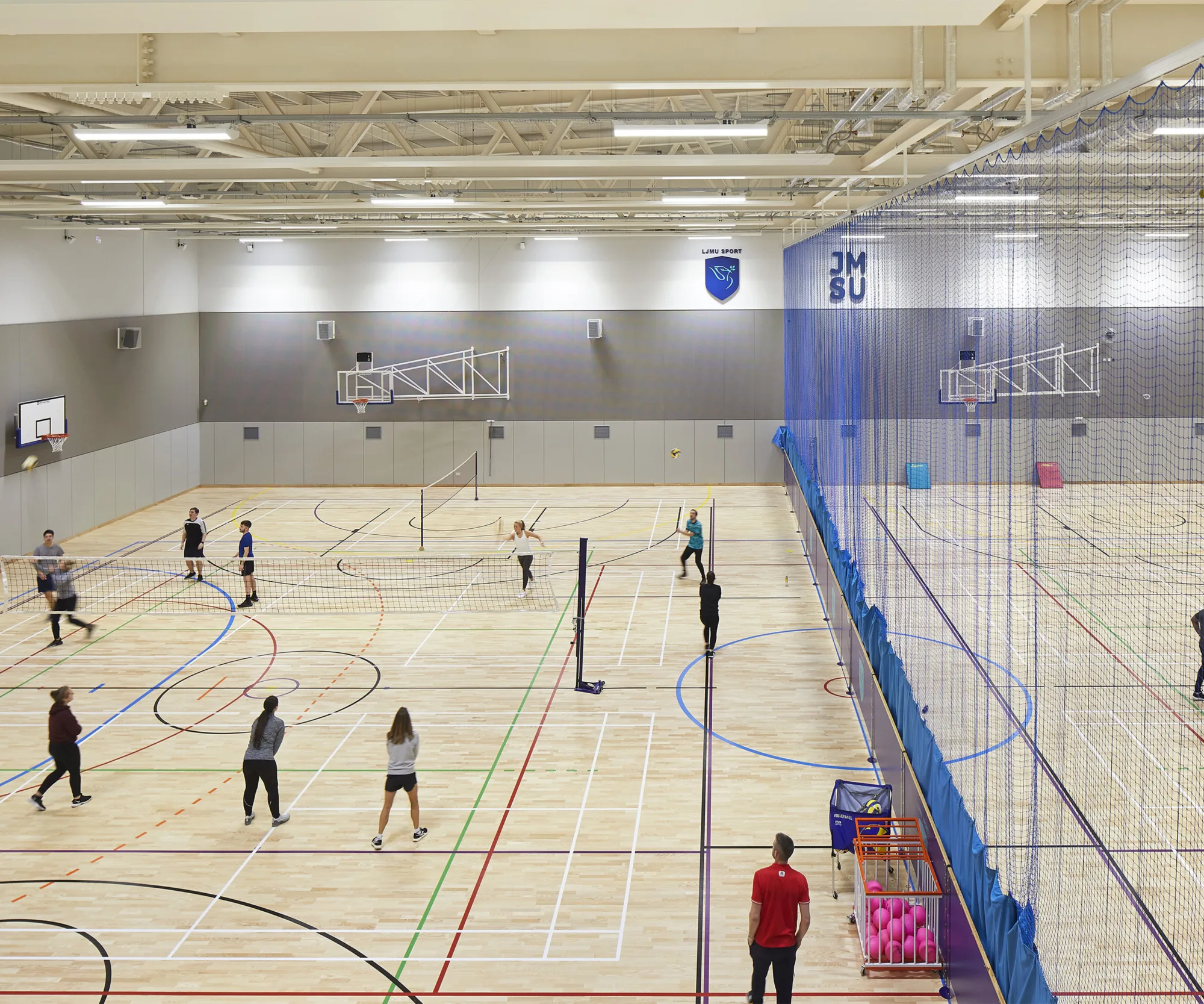 Sports hall with children playing volleyball