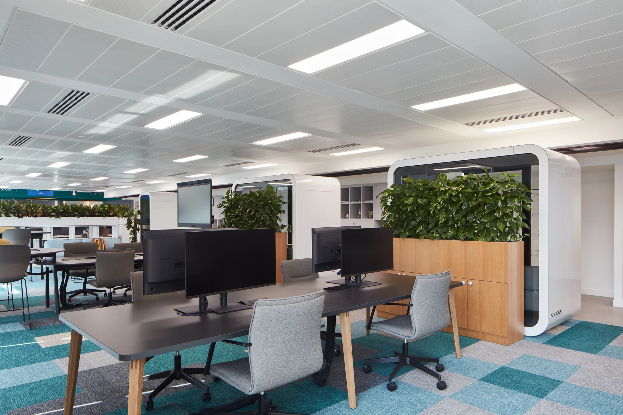 Linked In MENA Headquarters Open desk area with computer monitors and sound-proof meeting booths