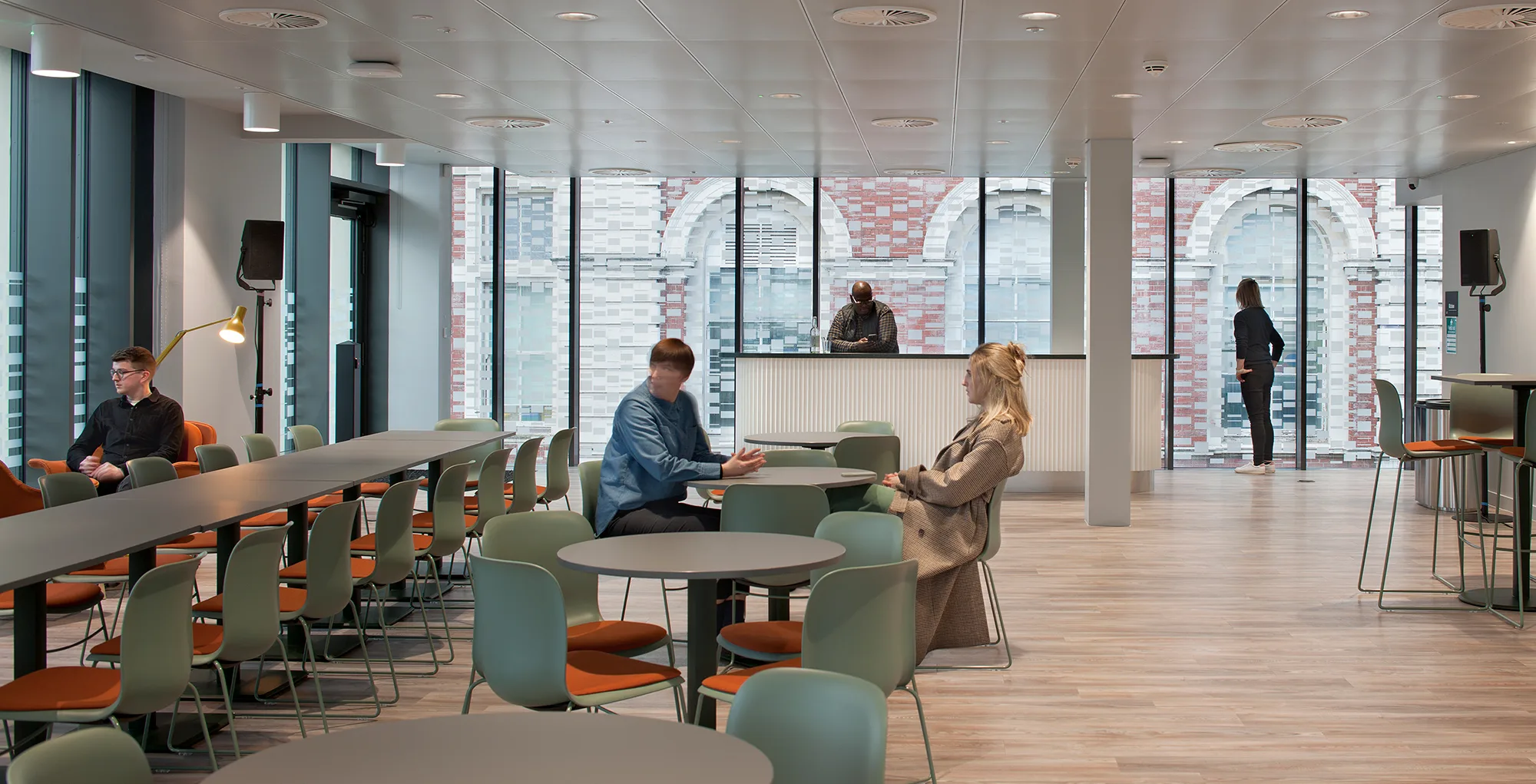 seating area with small and large tables with people at