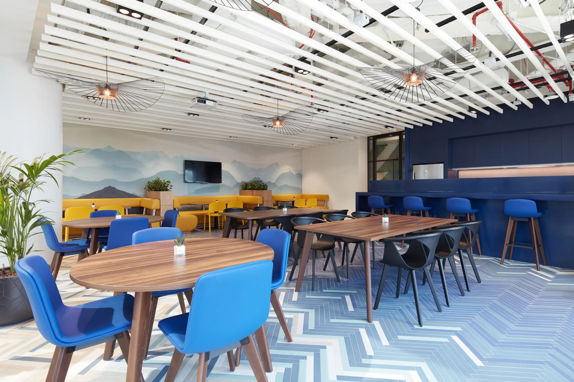 Natixis Dubai office pantry area with dining tables and kitchen