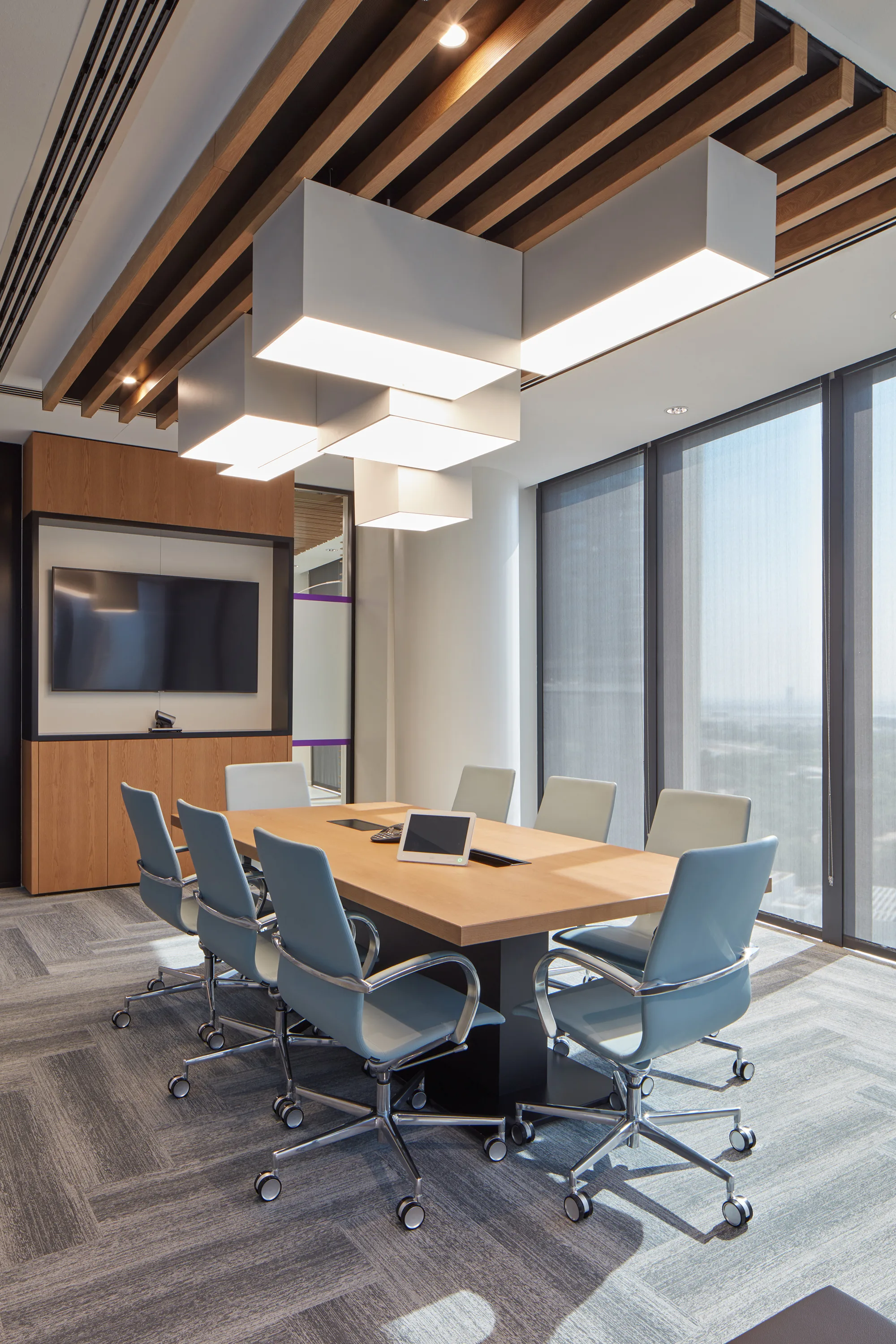 Natixis Dubai office meeting room with good natural light, long table that can accommodate 8 people and a TV.