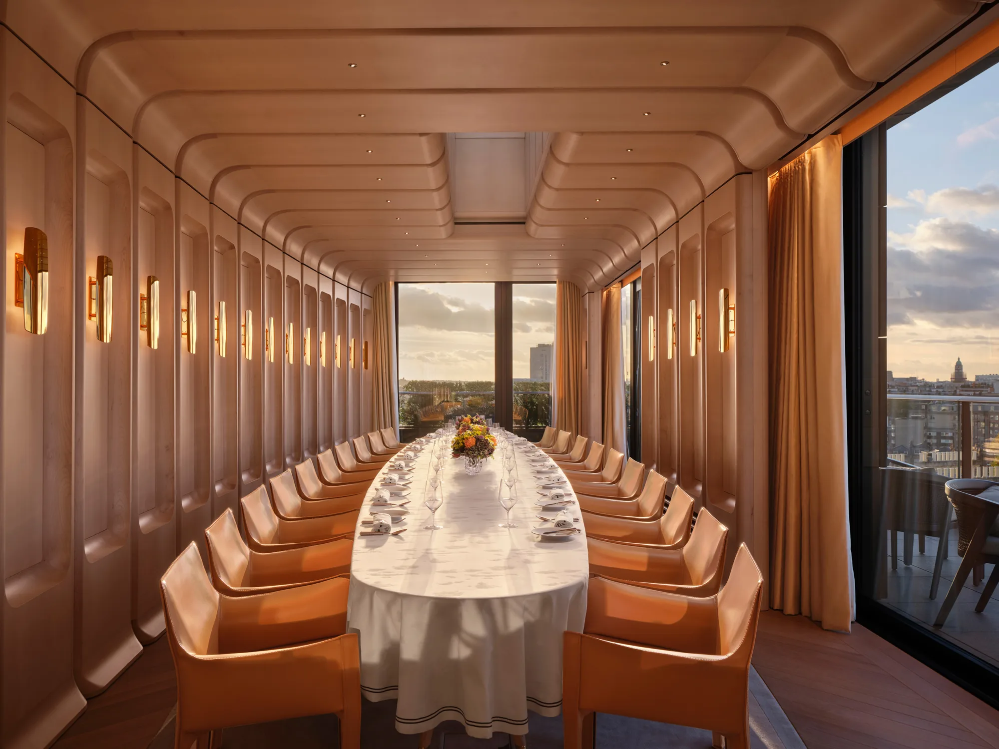 Peninsula Hotel private dinning room with a long table and orange seating.