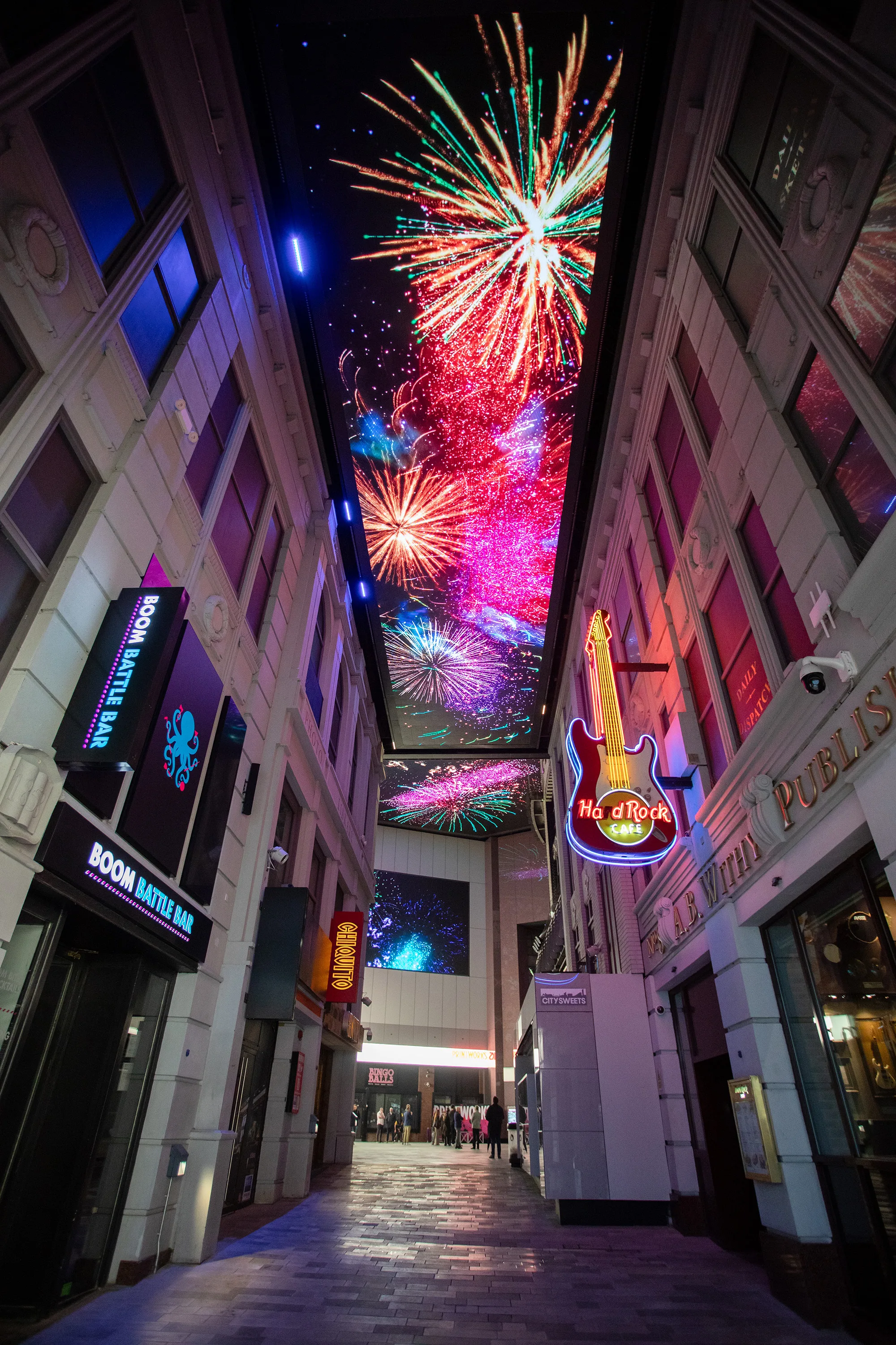 Colourful fireworks projected on the ceiling above the indoor alley way