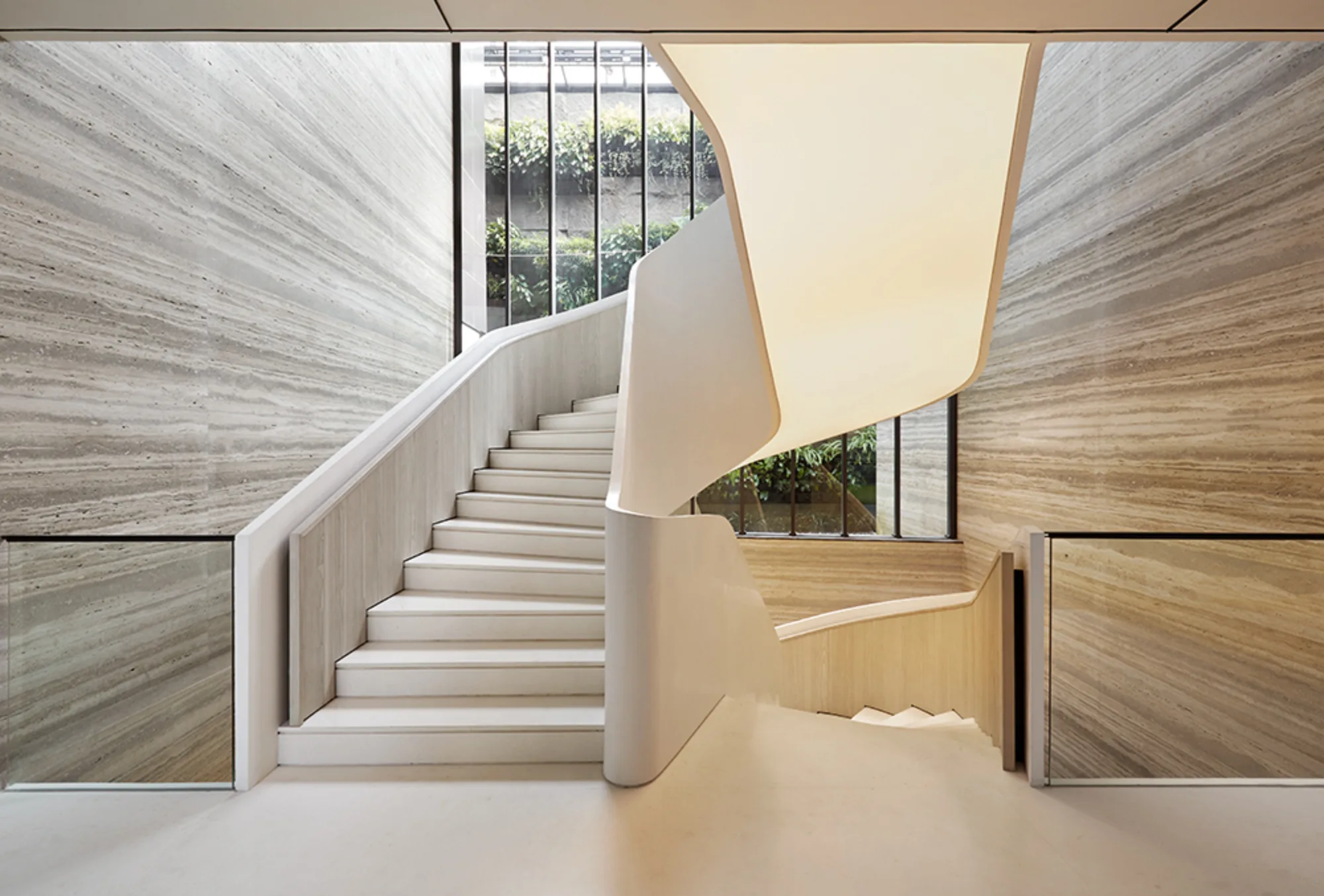 Staircase with lighting below, with glass railing and wooden effect cladded walls
