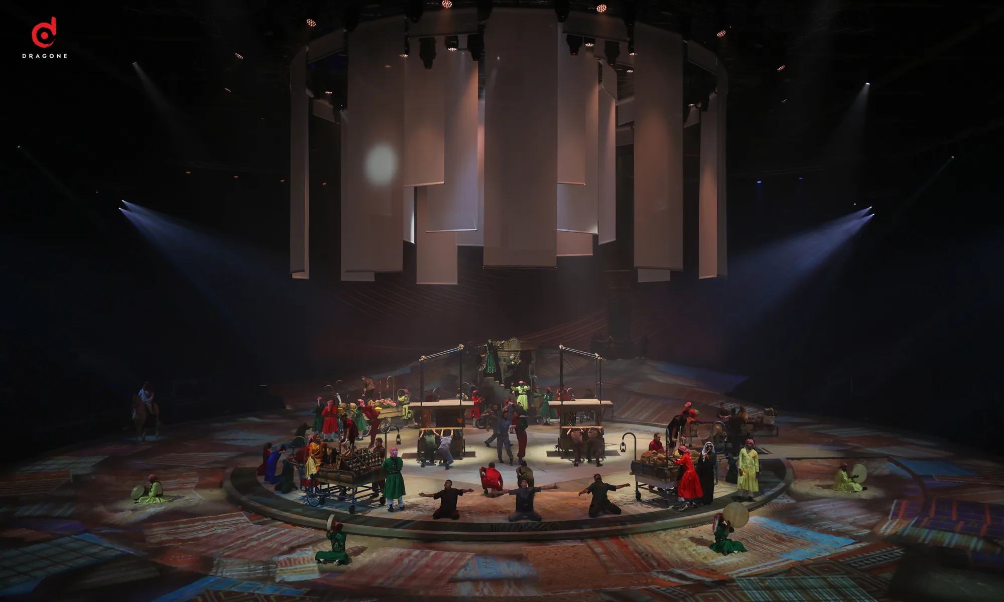 Alternative stage layout out with white panels hanging from ceiling while performers are underneath