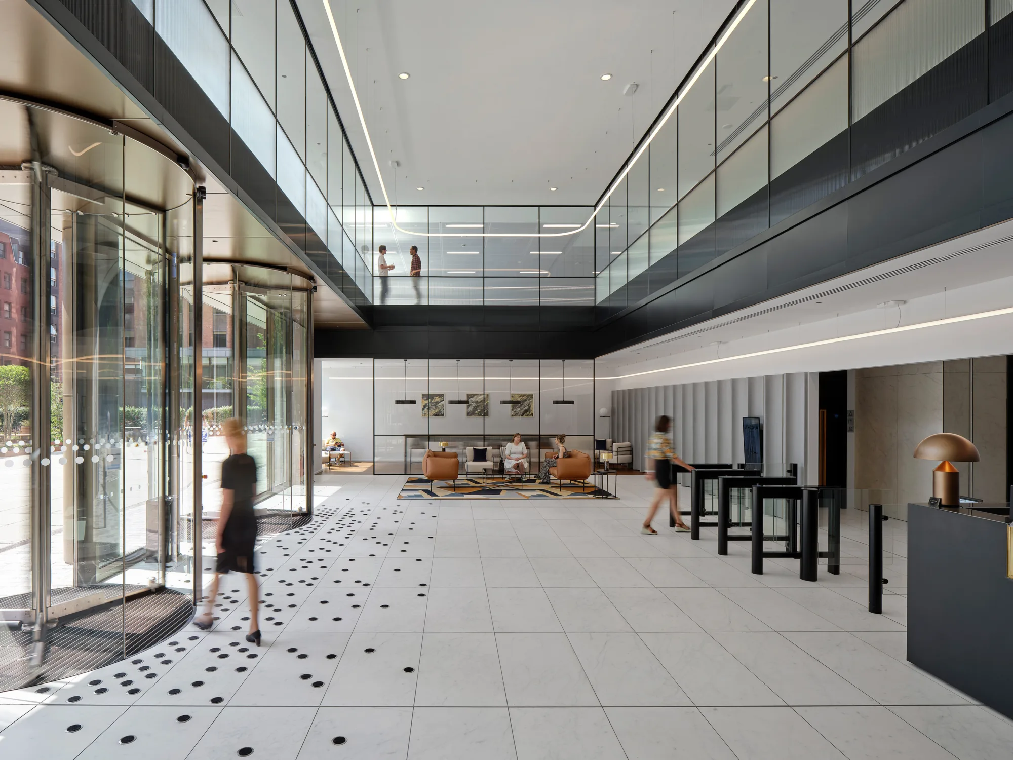 Entrance area of the building with rotating glass doors and a row of security gates