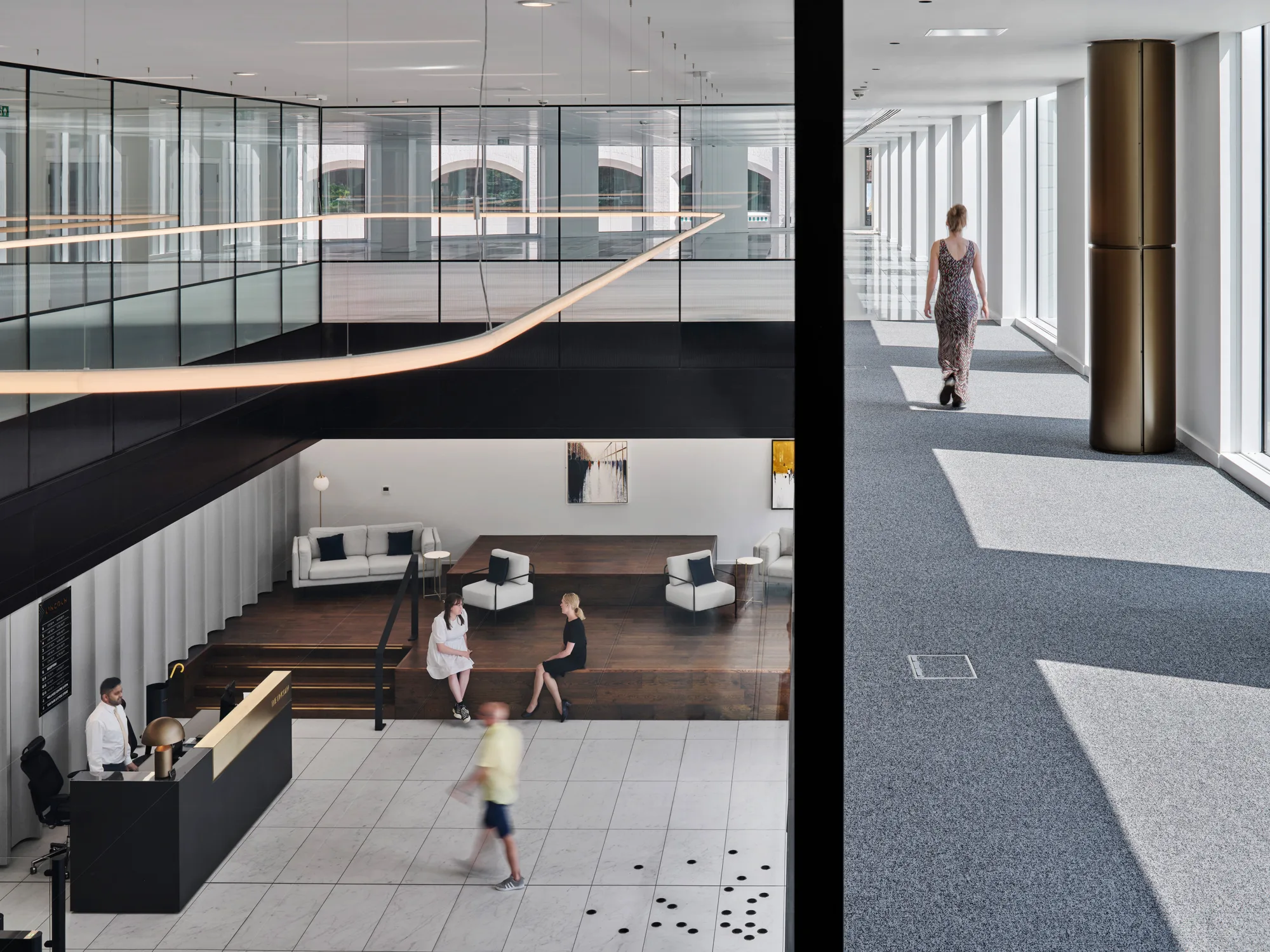 View from the second floor, looking down into the entrance area over the reception desk and seating