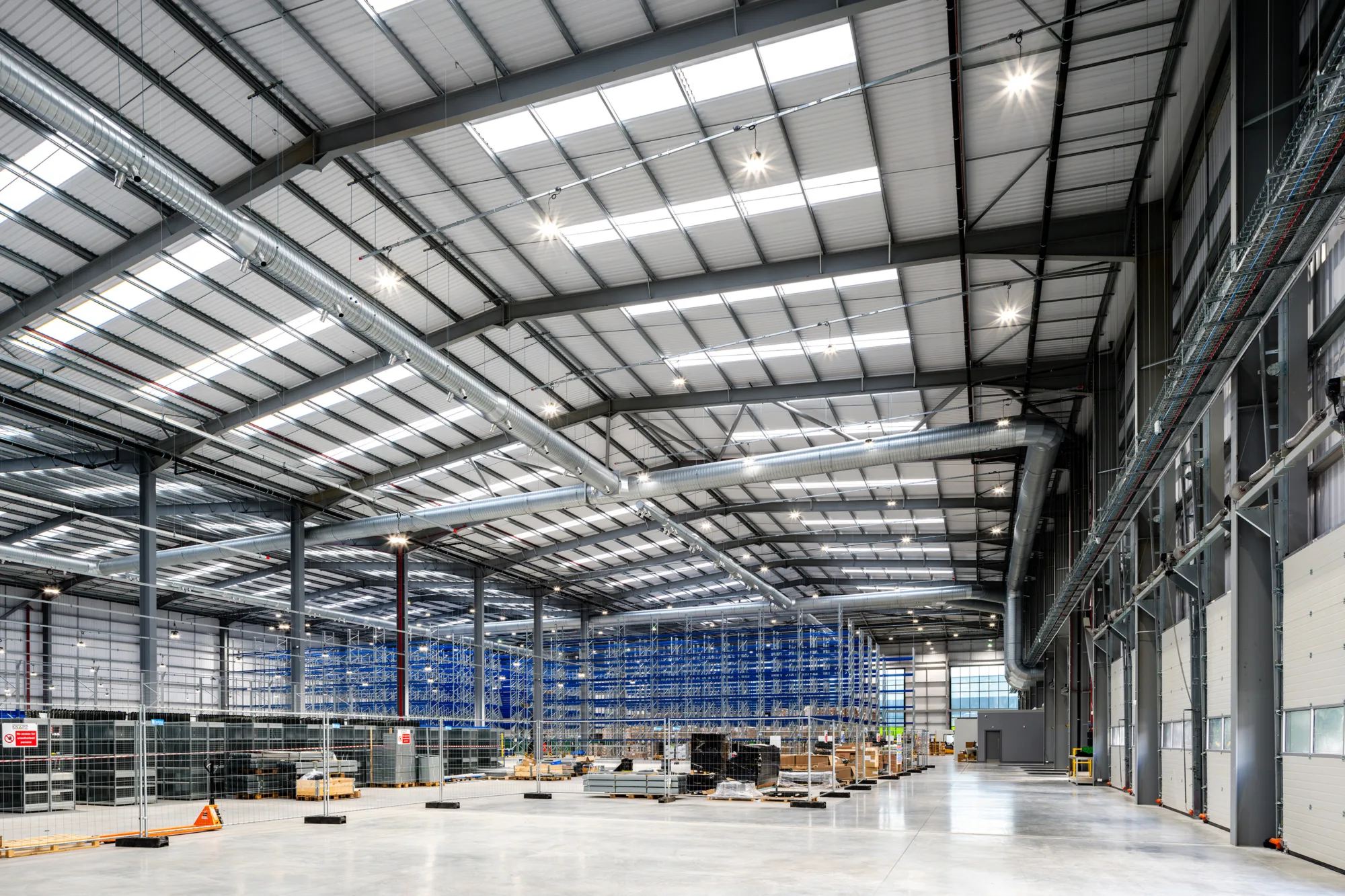 Inside the main warehouse hall of the Peak Pharmacy warehouse, with stock stacked on floor to ceiling shelves, in the Tudor Cross industrial complex.