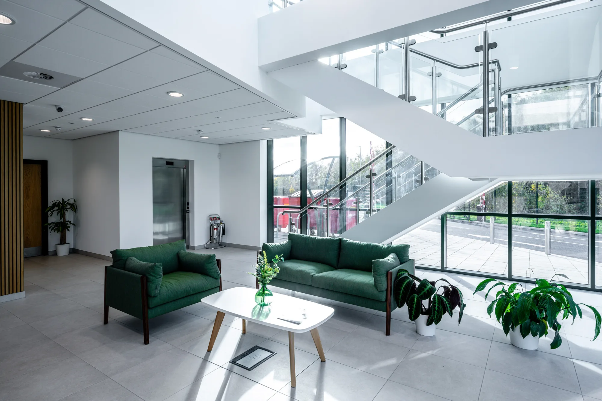 A well lit waiting area with a table and sofas in the front reception of the Peak Pharmacy warehouse in the Tudor Cross industrial complex.