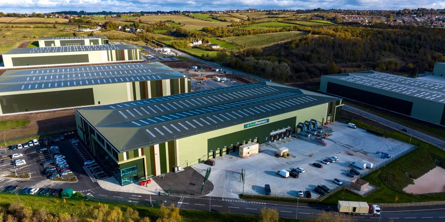 A wide shot of a distribution and warehouse space in the Tudor Cross industrial complex with the motorway and countryside surrounding it.
