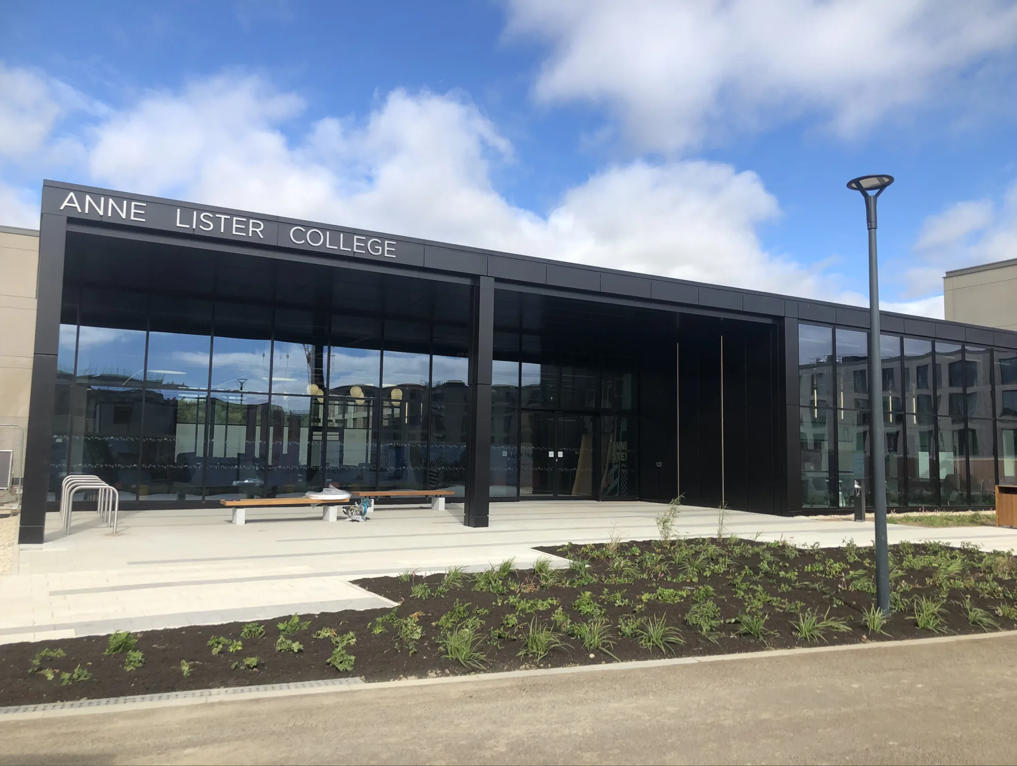 Exterior of the north hub, a dark grey building with a metallic sign reading 'Anne Lister College'