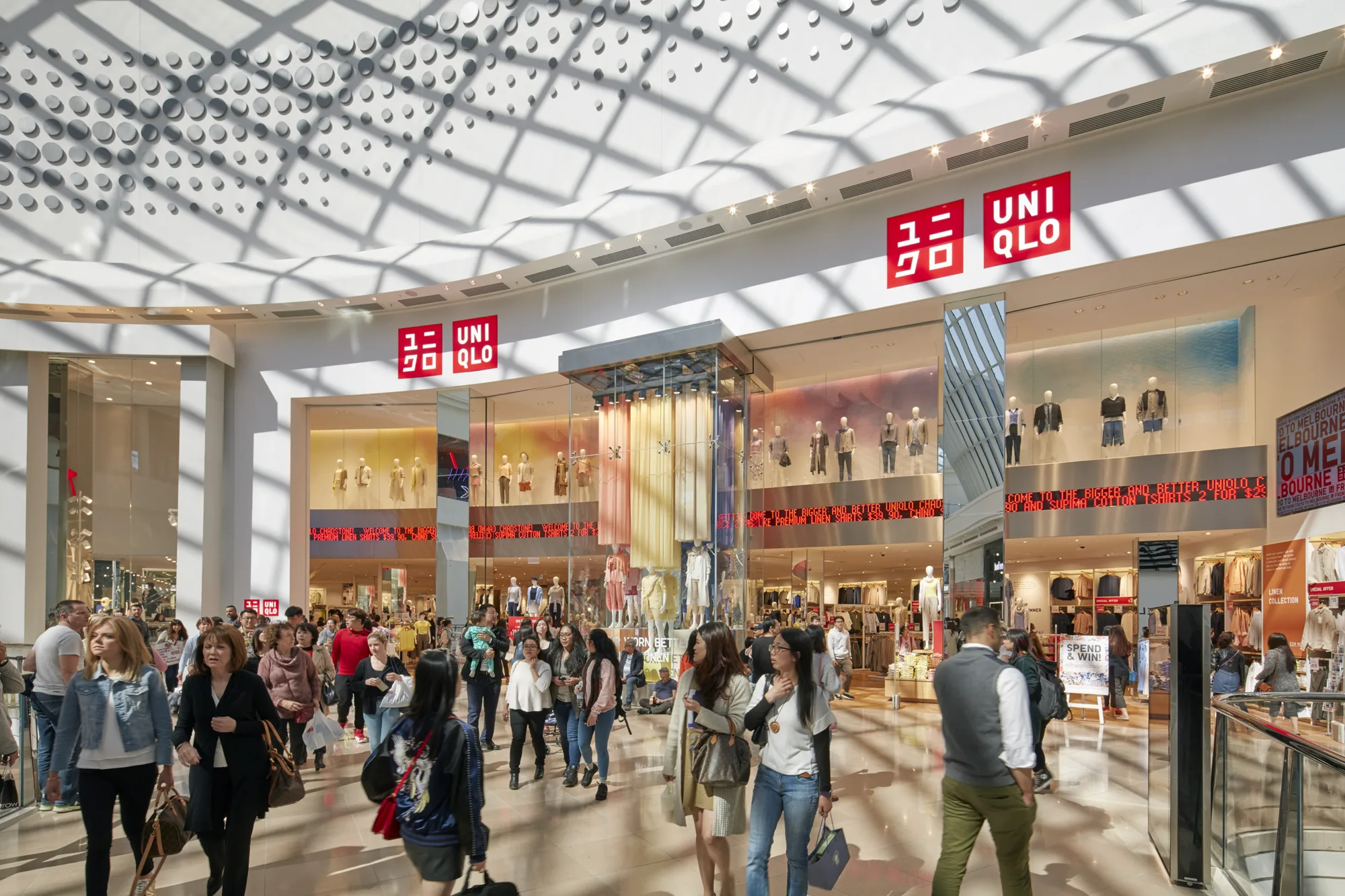 Shadows cast by roofing across Uniqlo shop front.