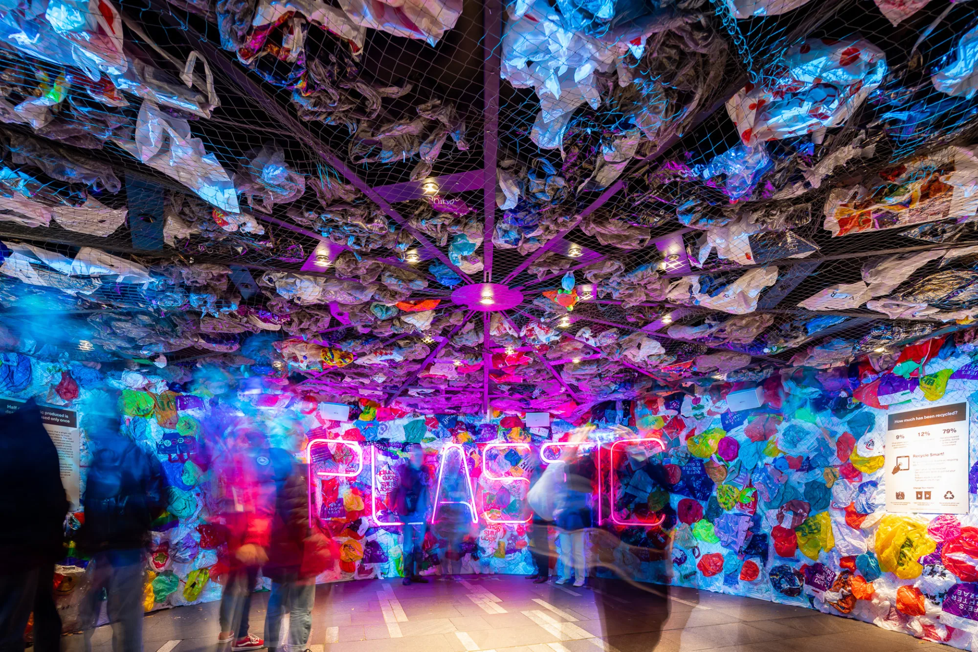 People viewing the interior of the installation, the work PLASTIC is across the back wall.