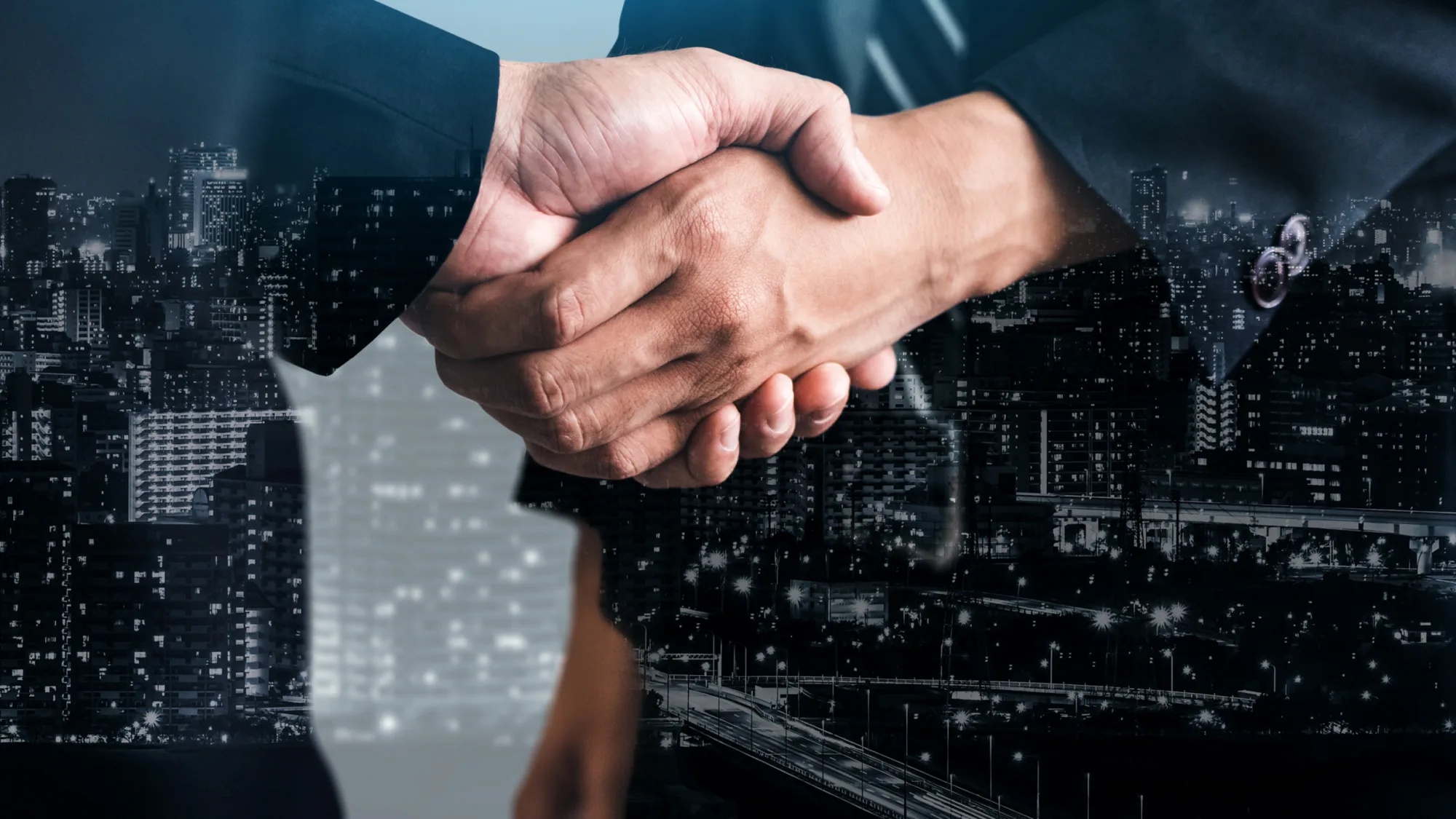 2 hands shaking with a cityscape montage on their suit outlines